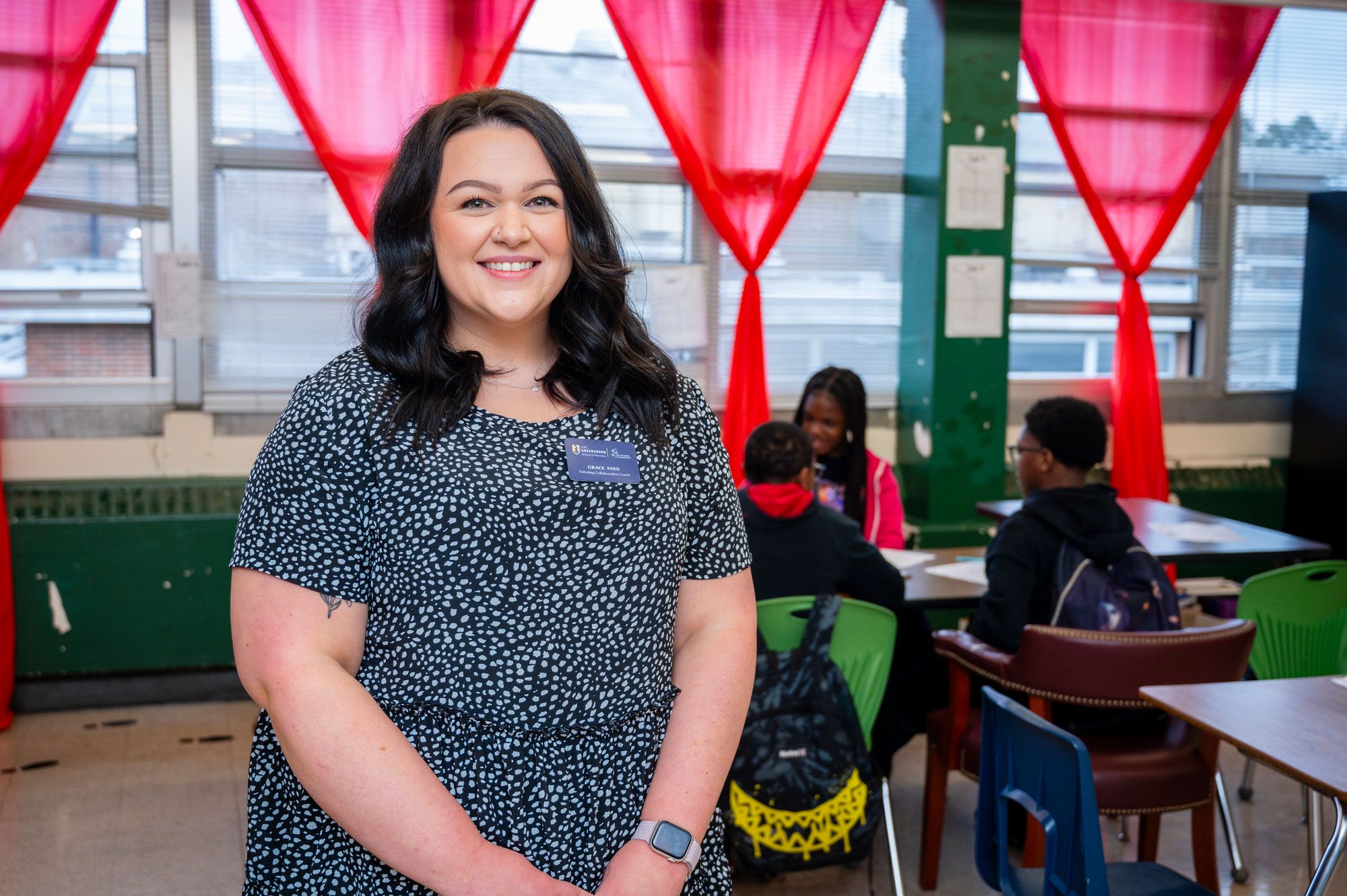 Grad student posed in front of tutoring small group