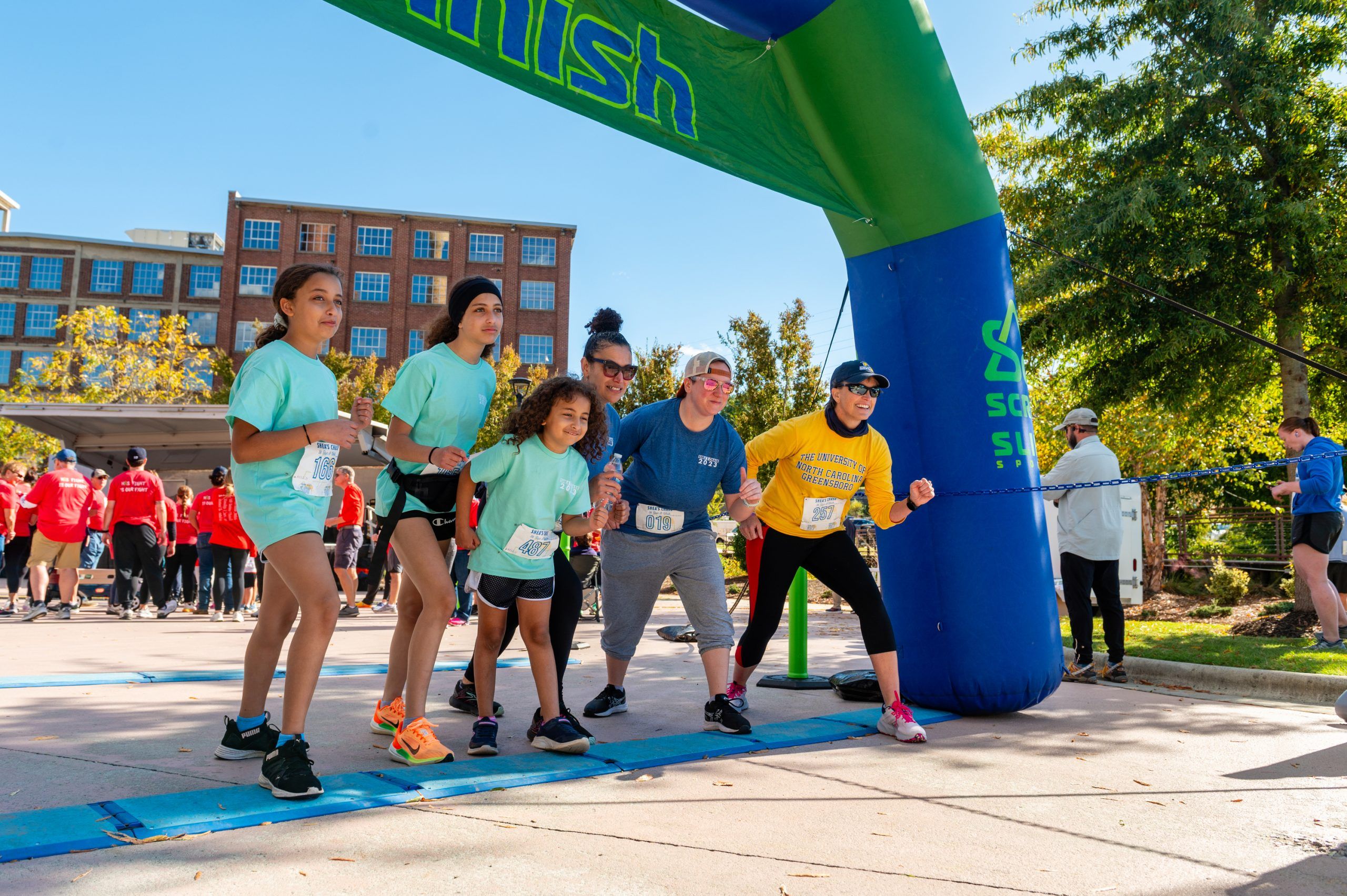 Runners posing at the finish line of.a 5K for mental health