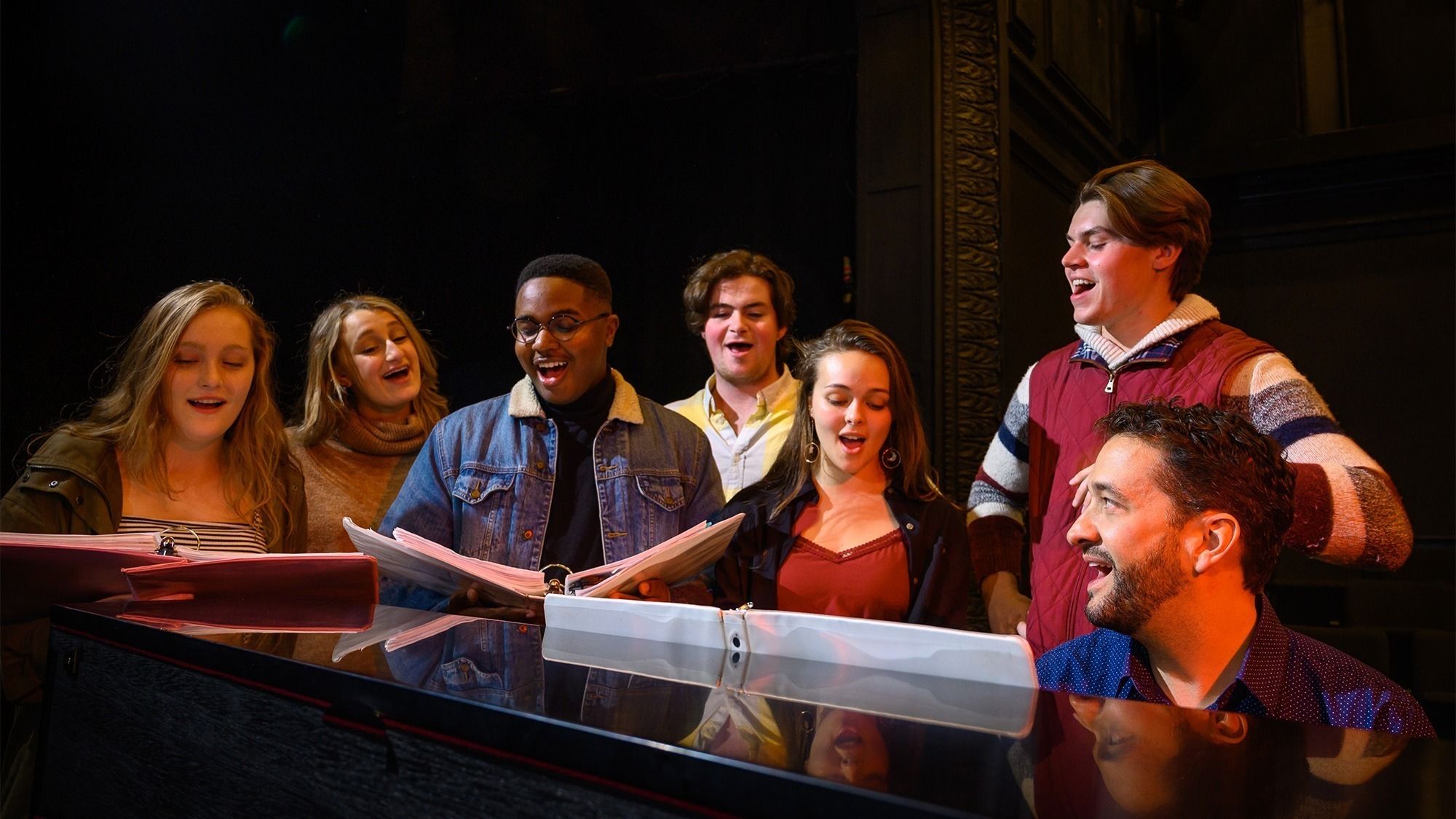 Dominick Amendum and studdents singing as he plays piano