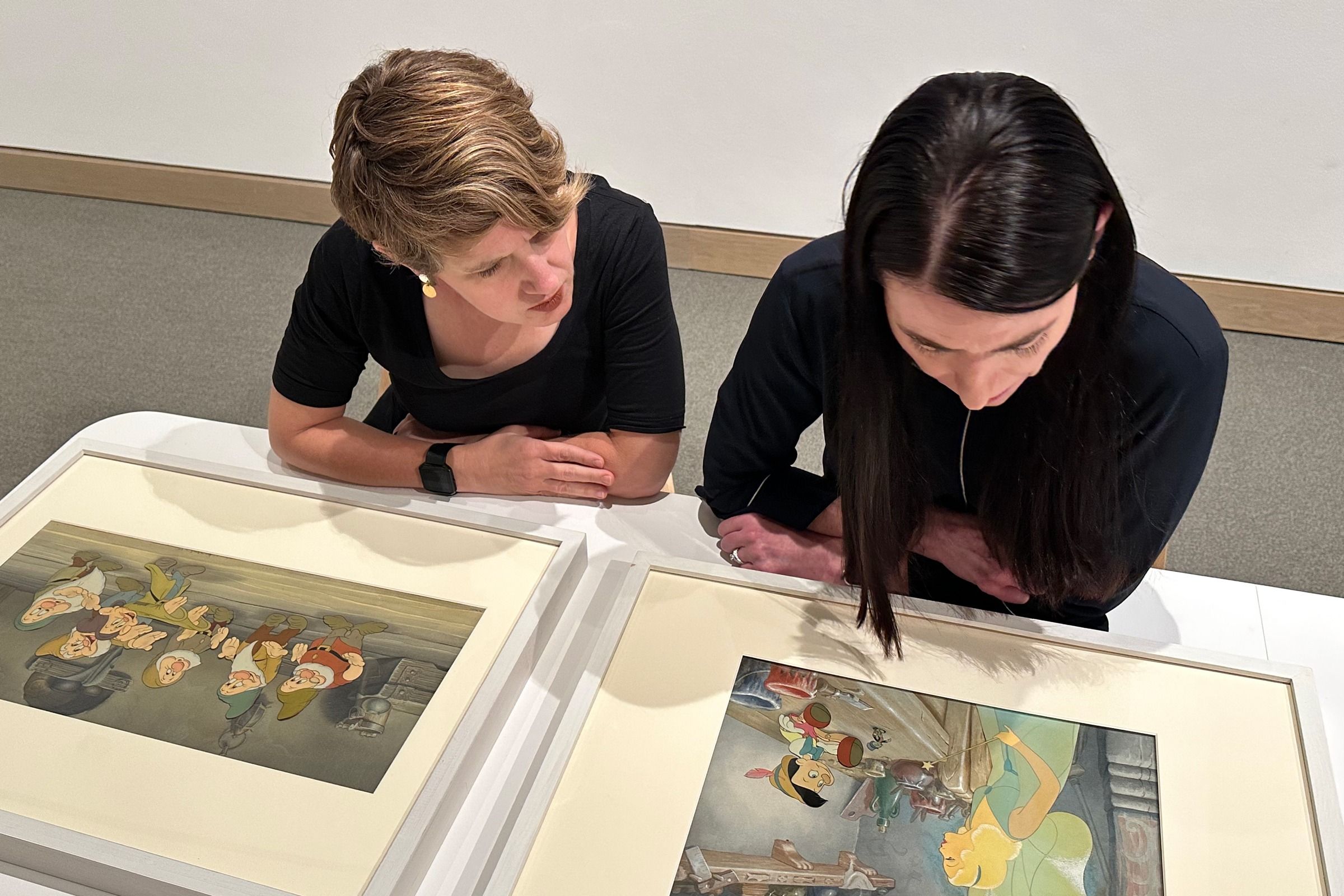 Holian and Stamey lookkng at prints from Snow White and Pinocchio