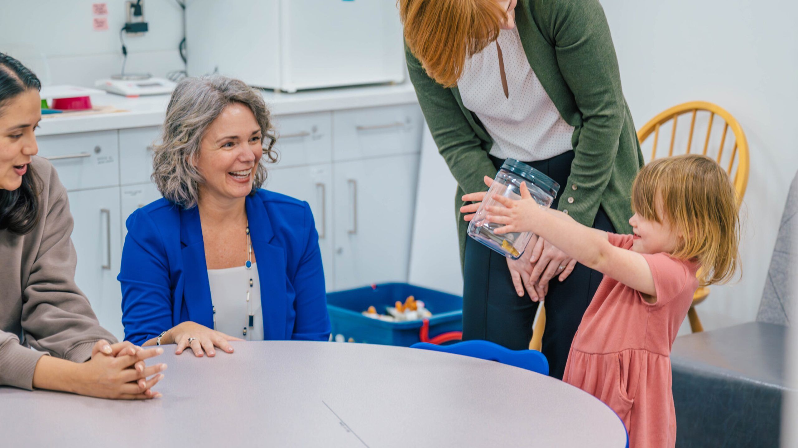 Toddler picking up jar for iGrow study while Leerkes, Sattler, and Negi observe