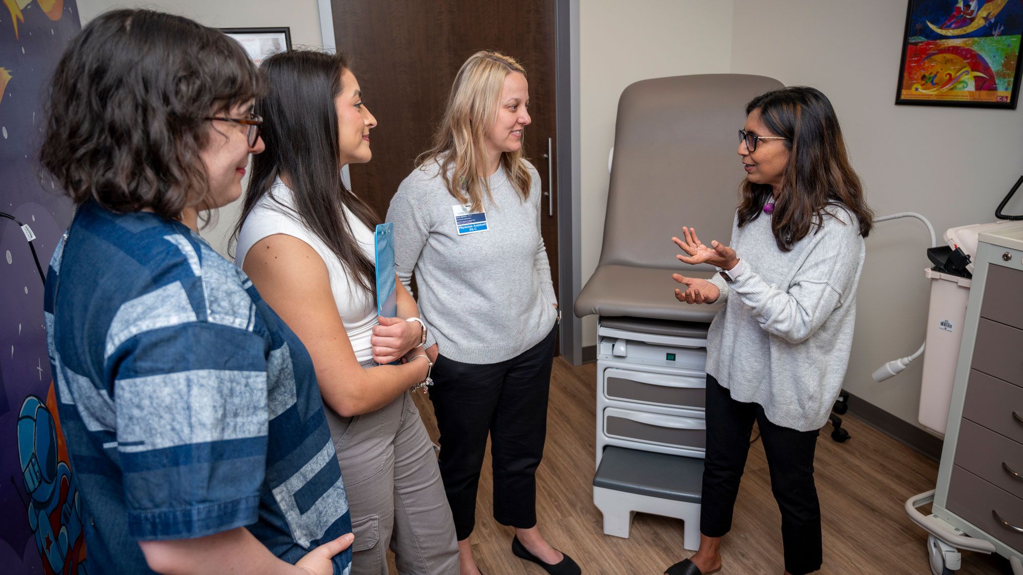 Dr. Jigna Dharod speaks with Jasmine DeJesus, Selena VIlla, and Julie Wenzel in an exam room