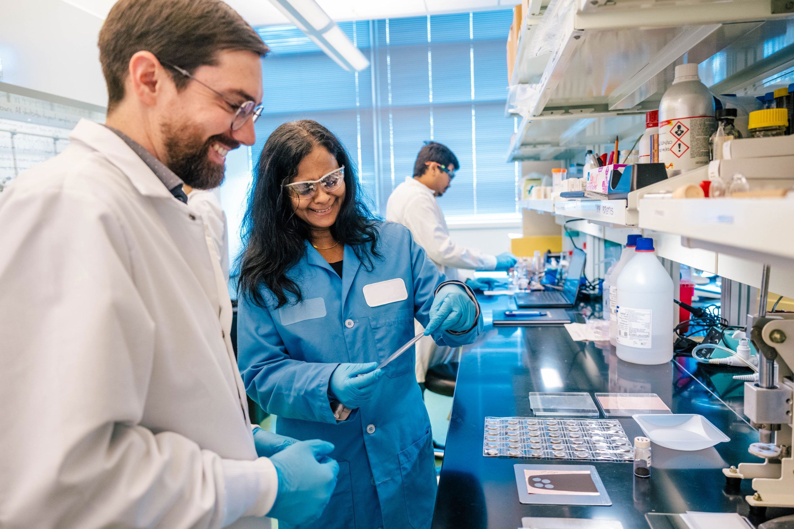 Two people in a lab examine a scan of a bone