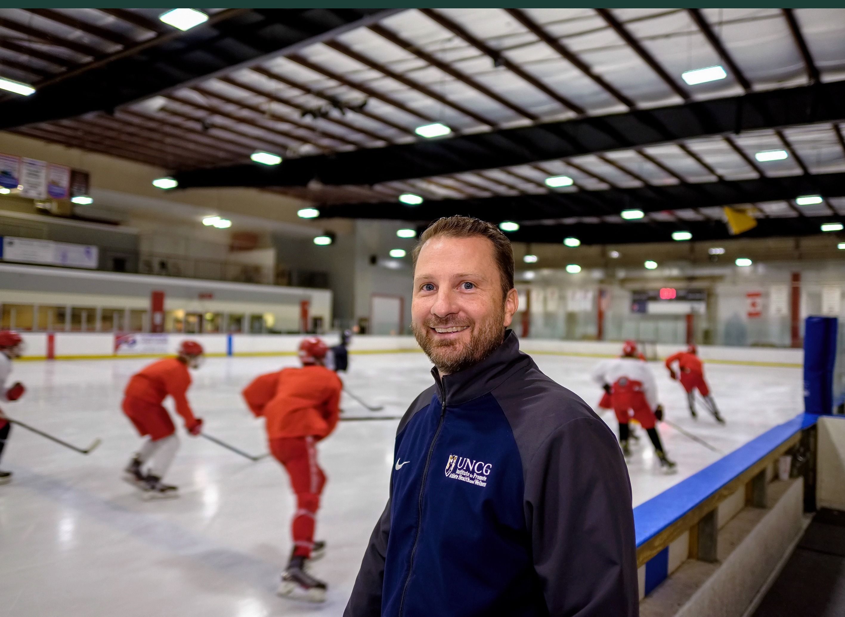 A person standing in front of a hockey rink