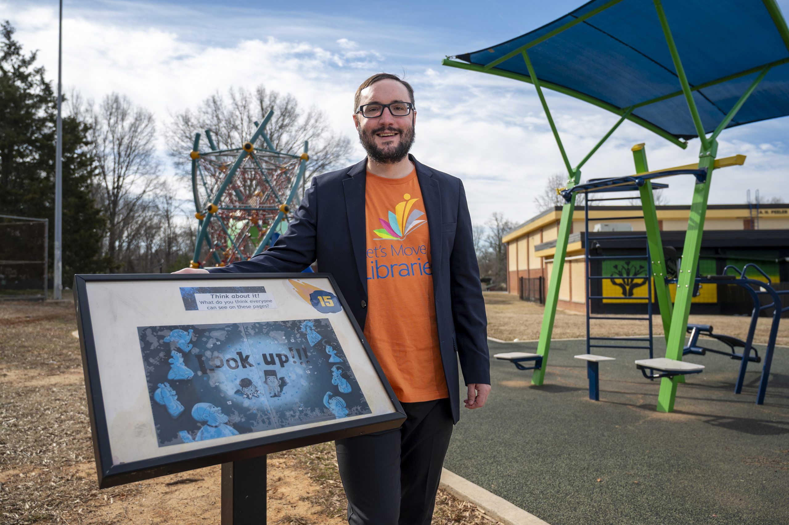 Dr. Noah Lenstra stands outside of a local library's book walk