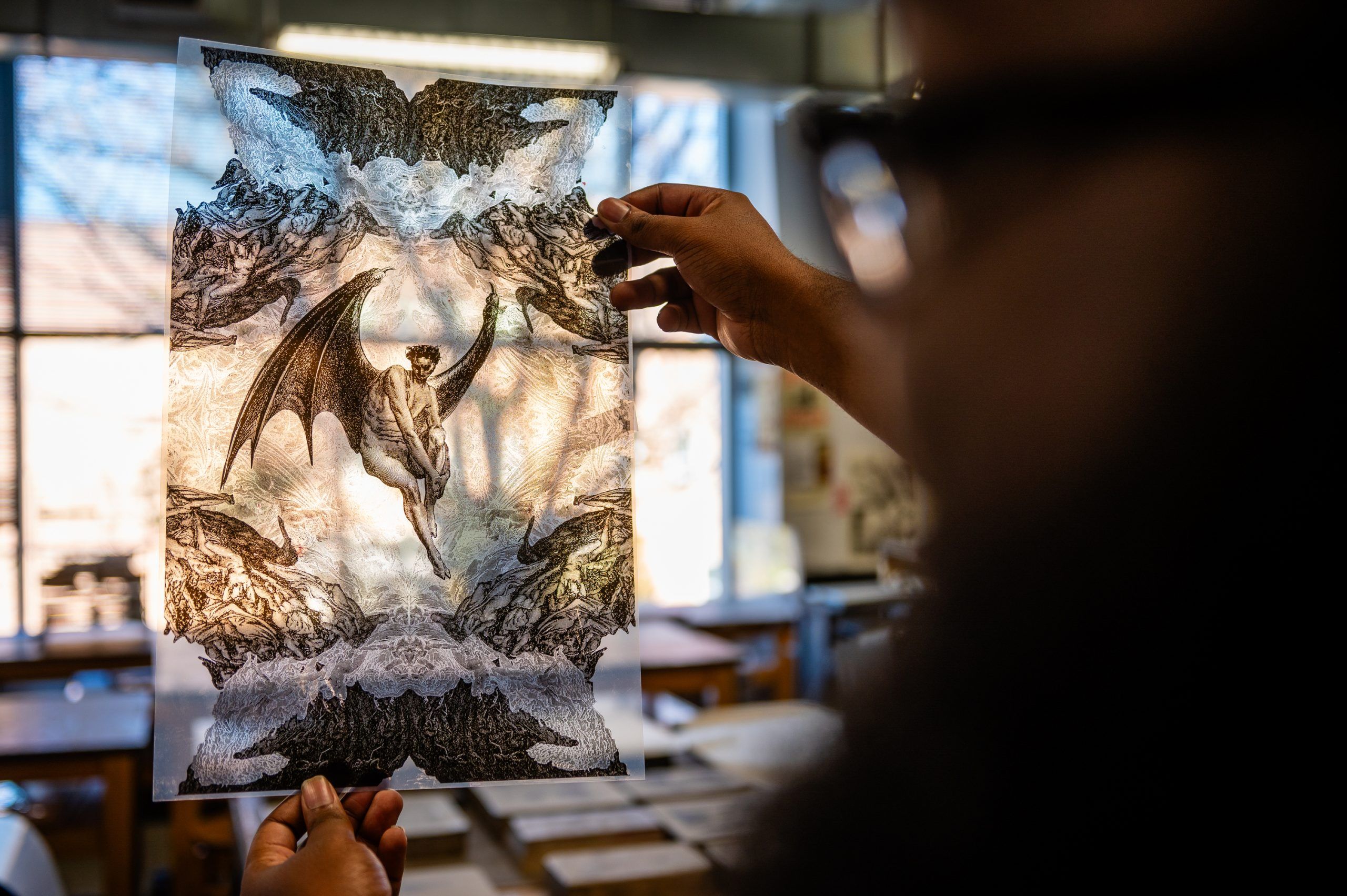 Miles-Moultrie holdoing up one of his prints to the light