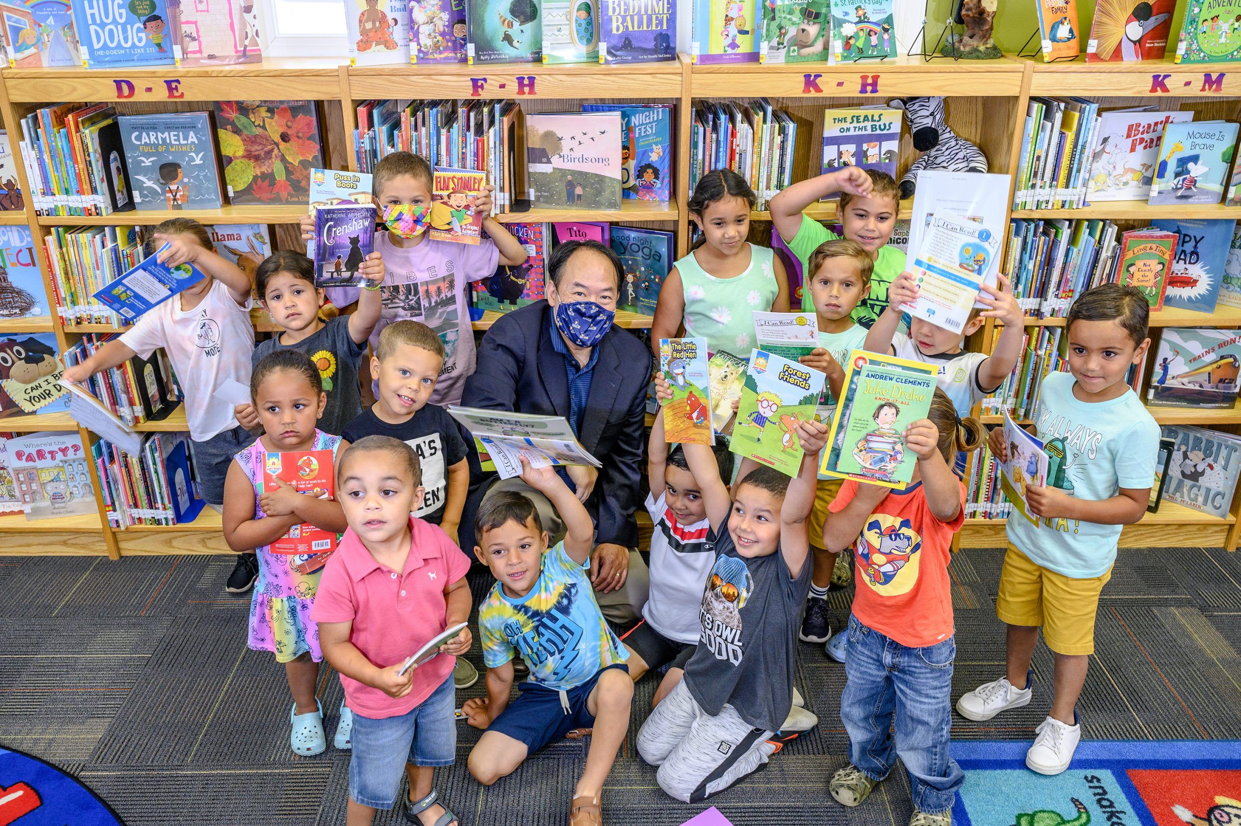 A group of children each posing with a book