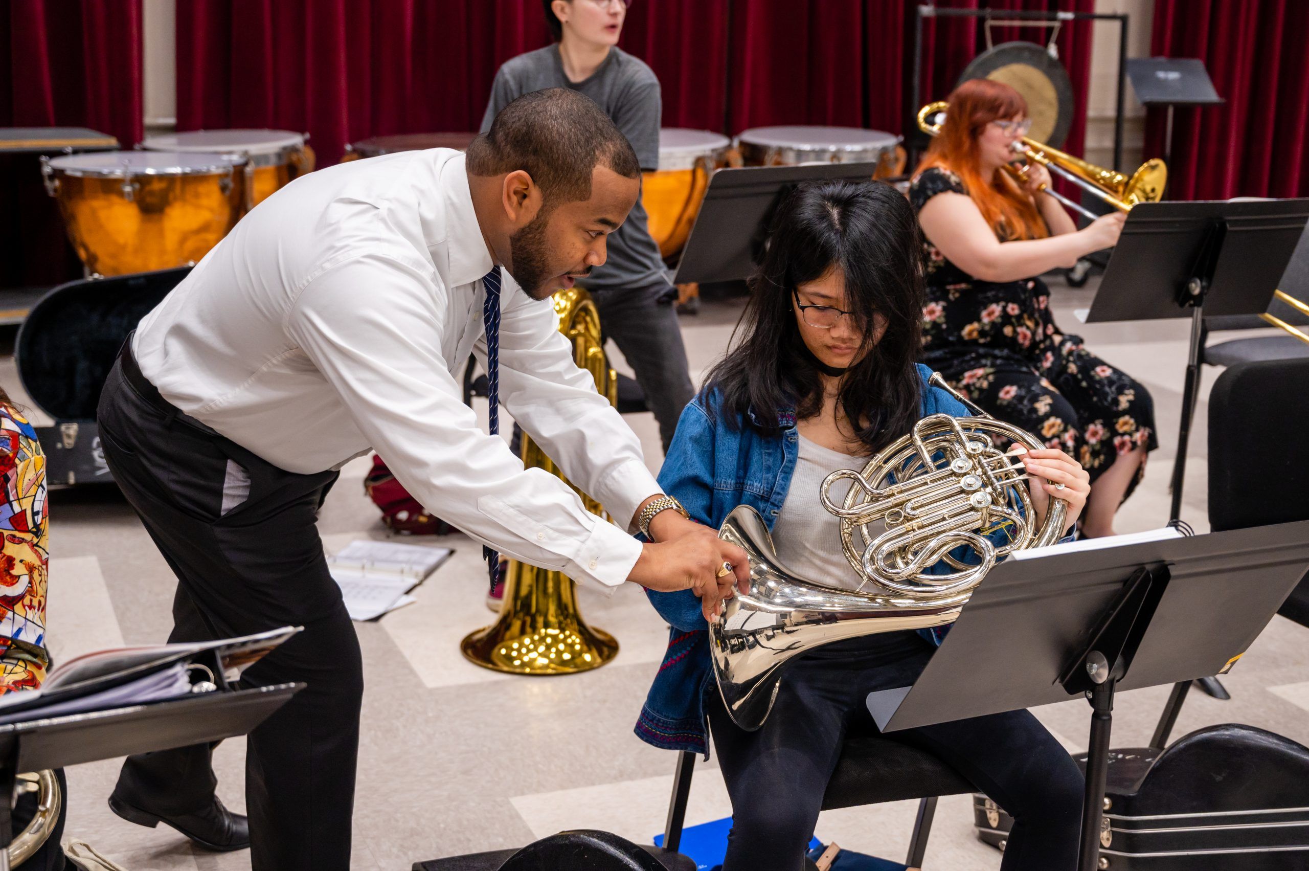 Dr. Parker assisting a student French horn player.