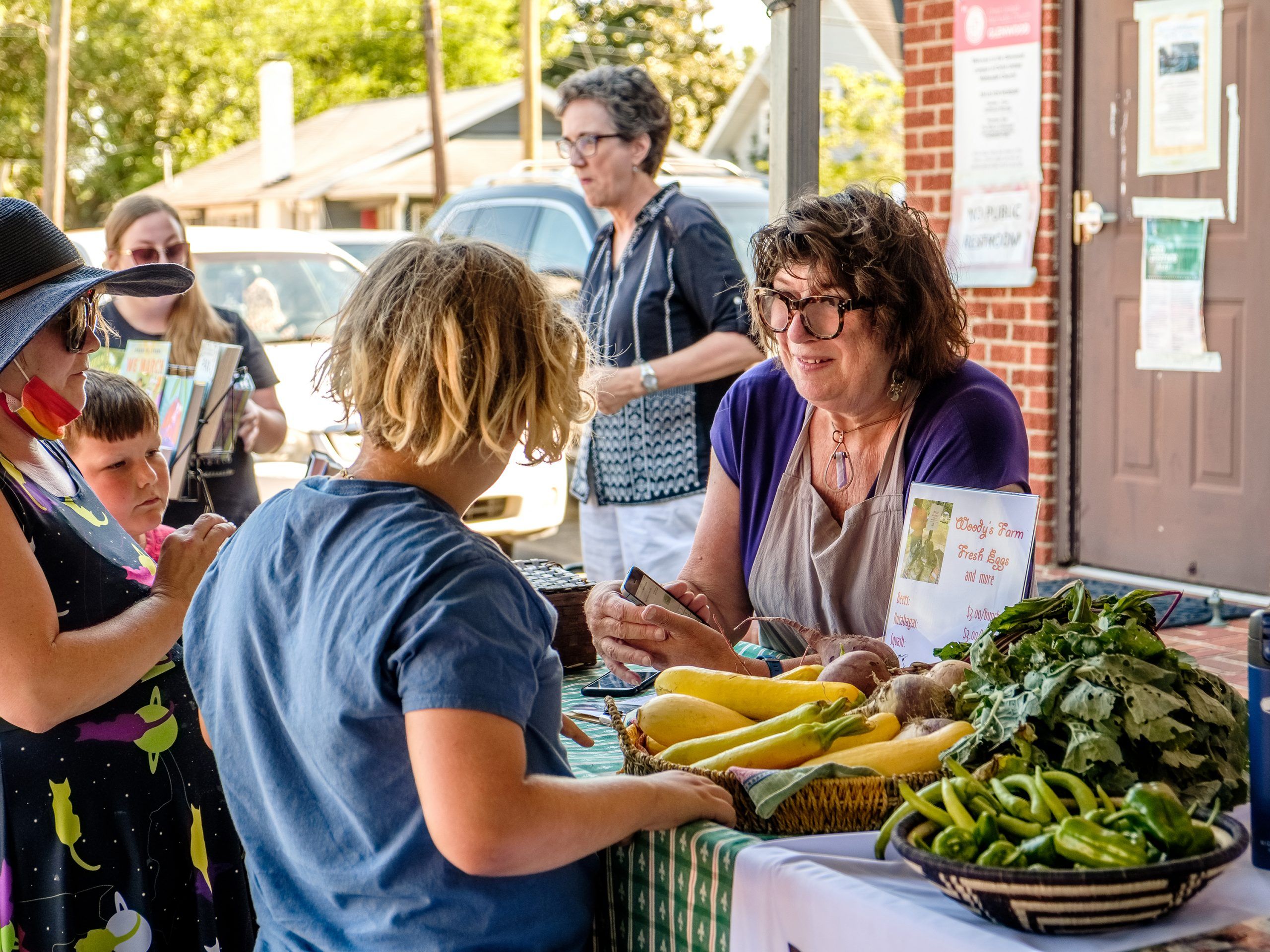 Market manager Liz Seymour running cards and handing out tokens for the Green for Greens program.