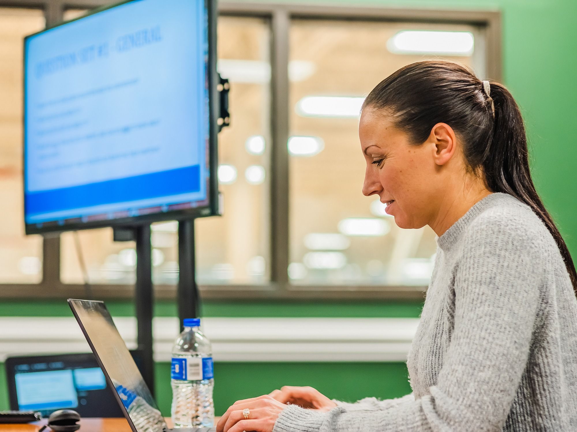 A woman advances a PowerPoint during a focus group meeting.