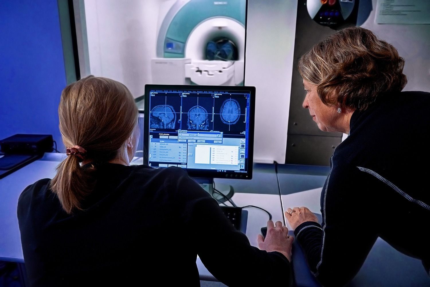 Dr. Etnier and a graduate student look at MRI scan results on a computer.
