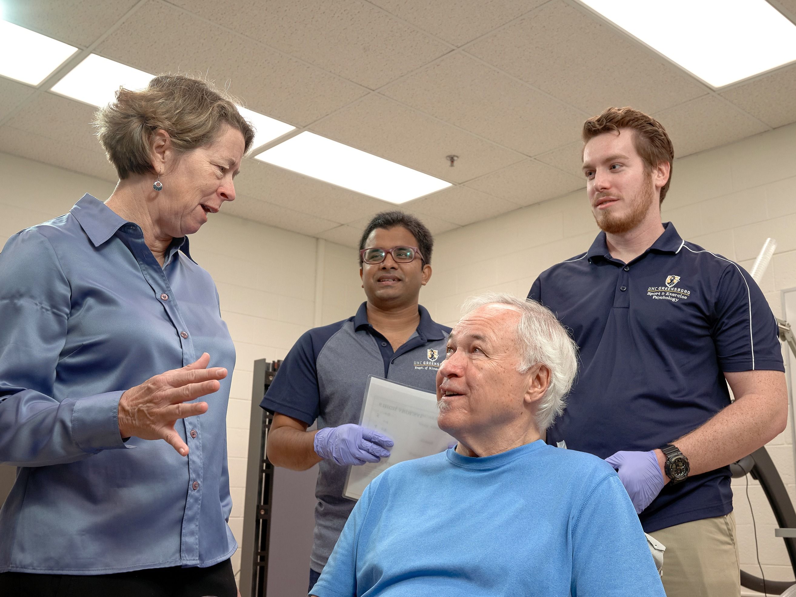 Dr. Etnier and two grad students talk to a seated research participant.