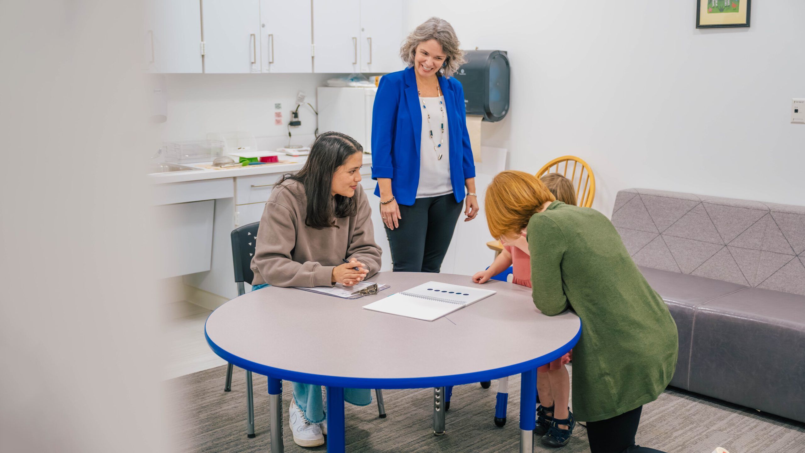 Sattler and researchers working with a toddler