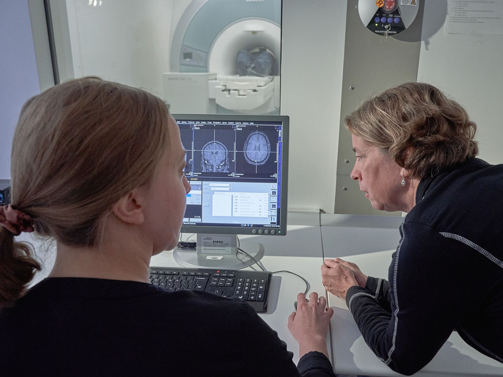 Dr. Etnier and Alexis Ganesh look at the MRI output on a computer screen.