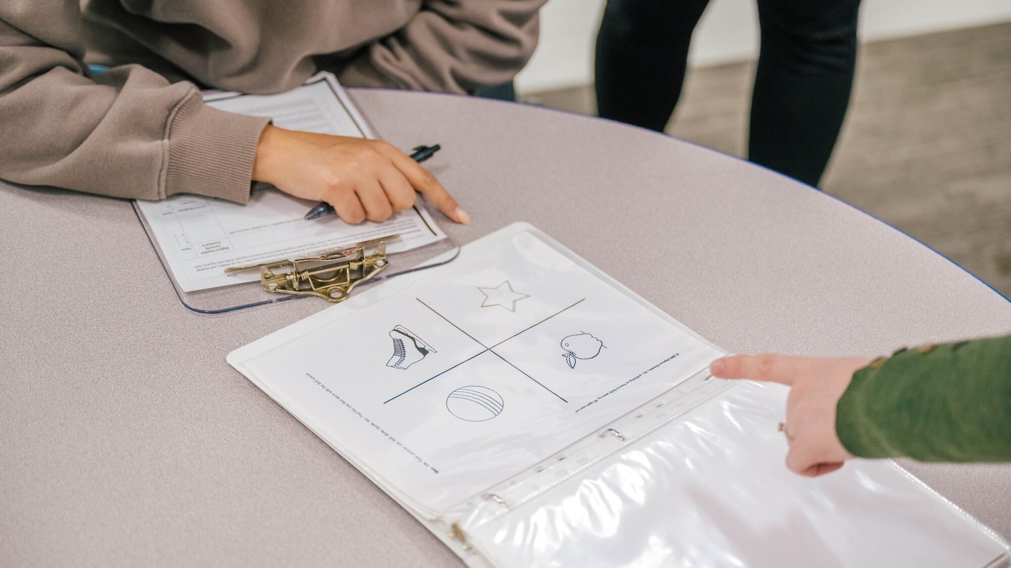 A toddler pointing at an apple at the instruction of a grad student