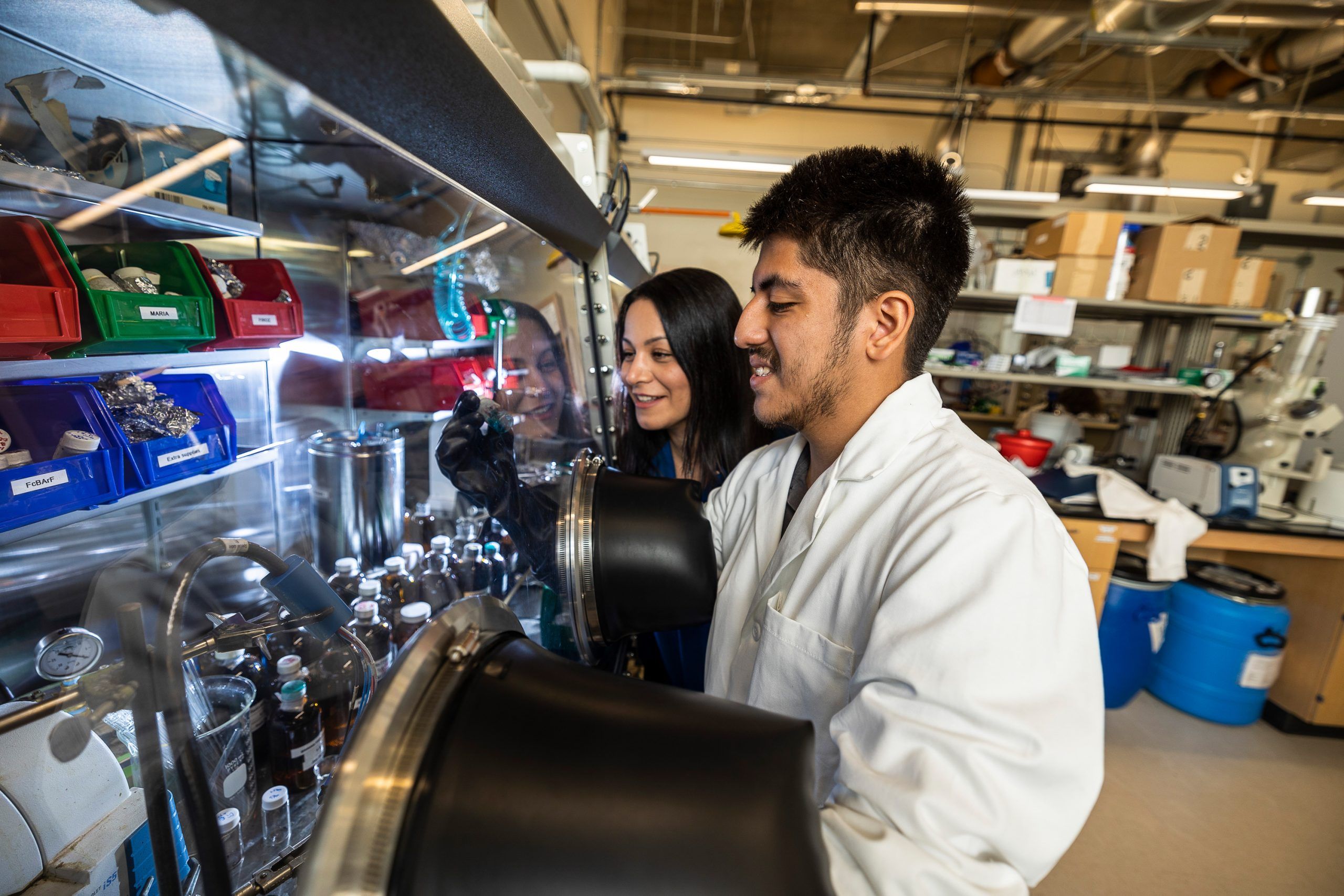 Undergrad Marcos Tapia working with samples while standing with Dr. Hermatian as 