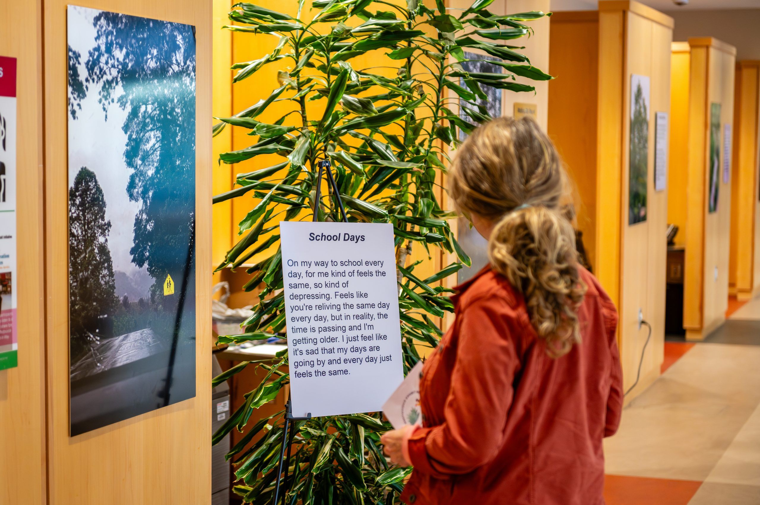 A student observing a participant's piece titled "School Days"