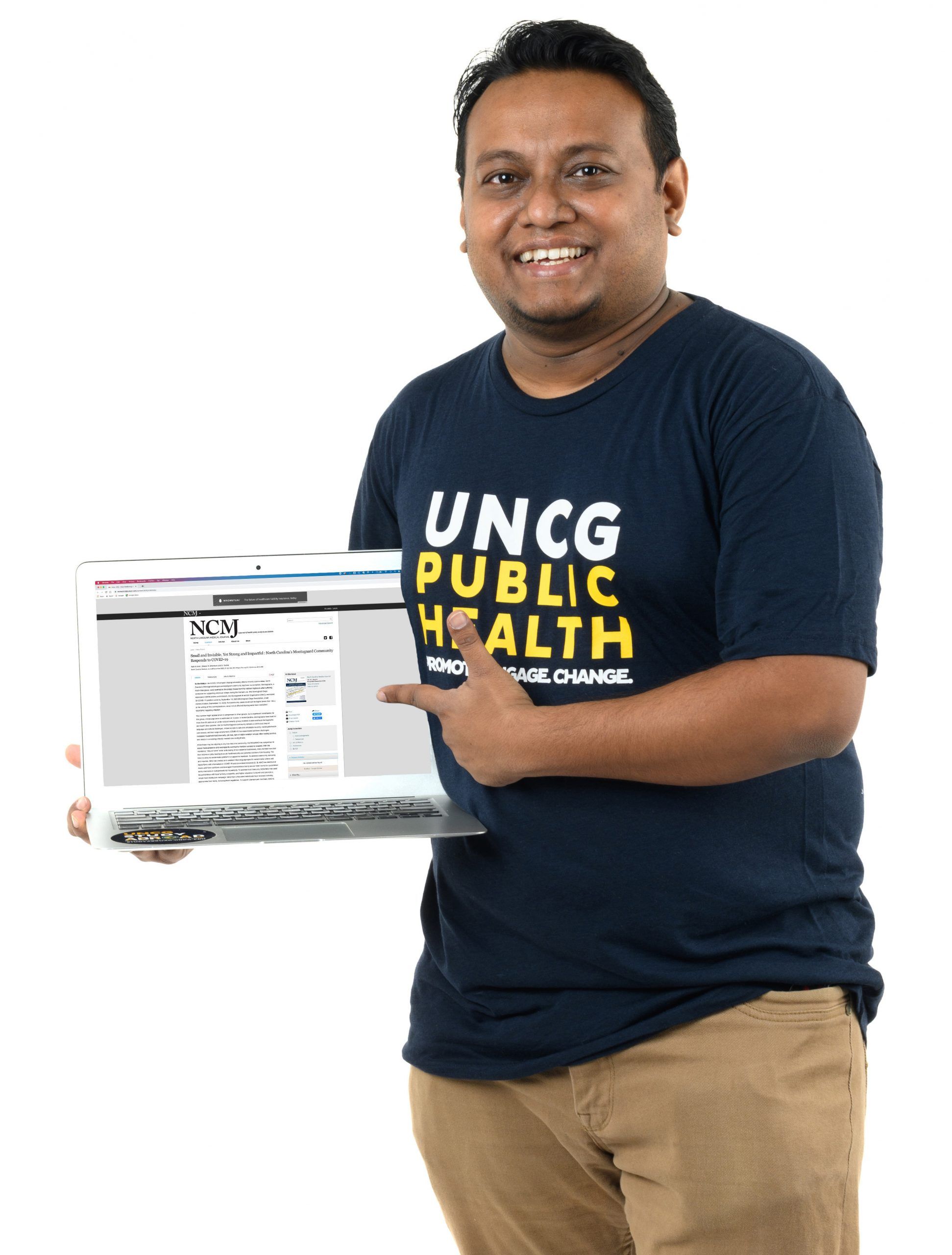 Saif Al Amin holding a laptop displaying an academic journal. 