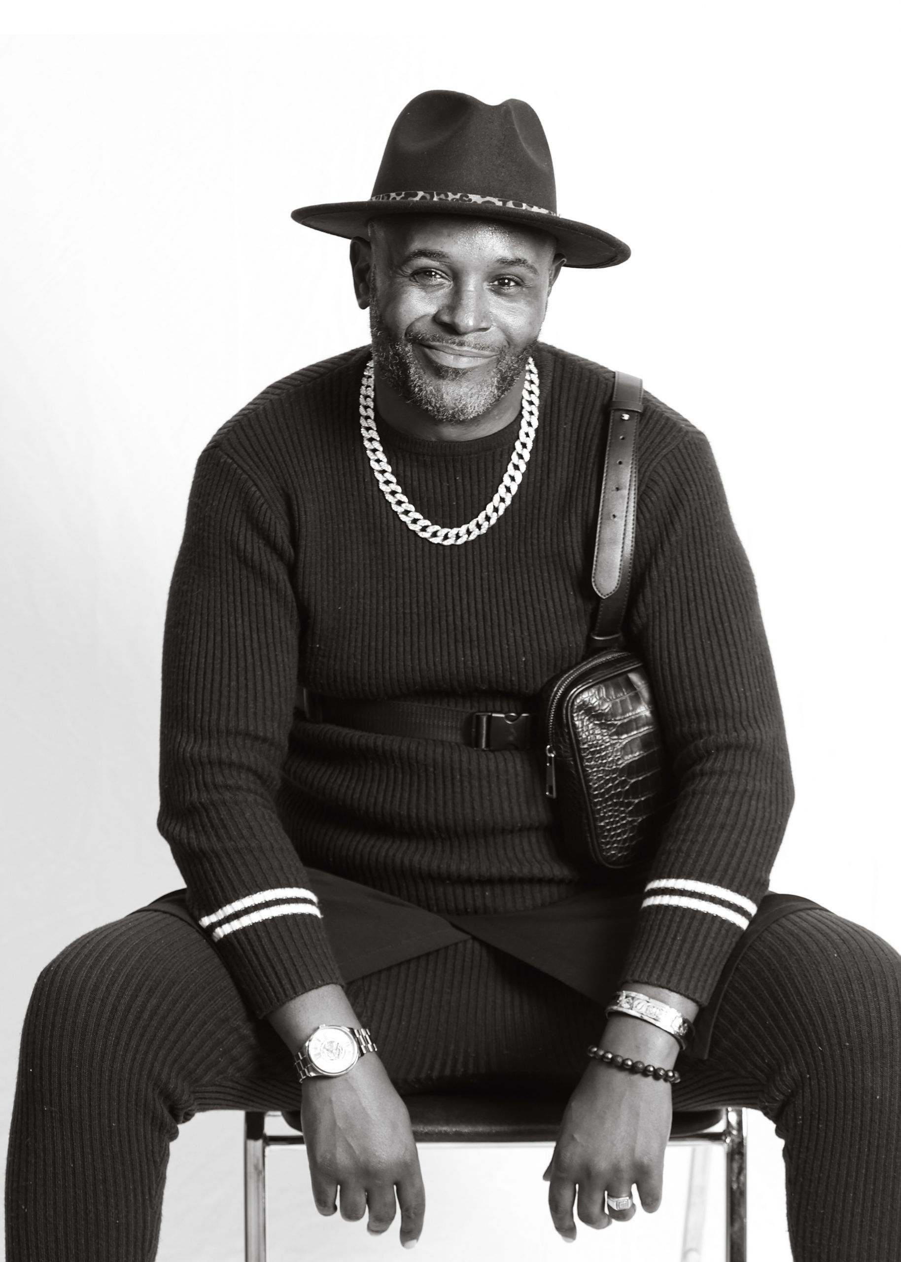 A black and white photo of a Black man wearing a hat.