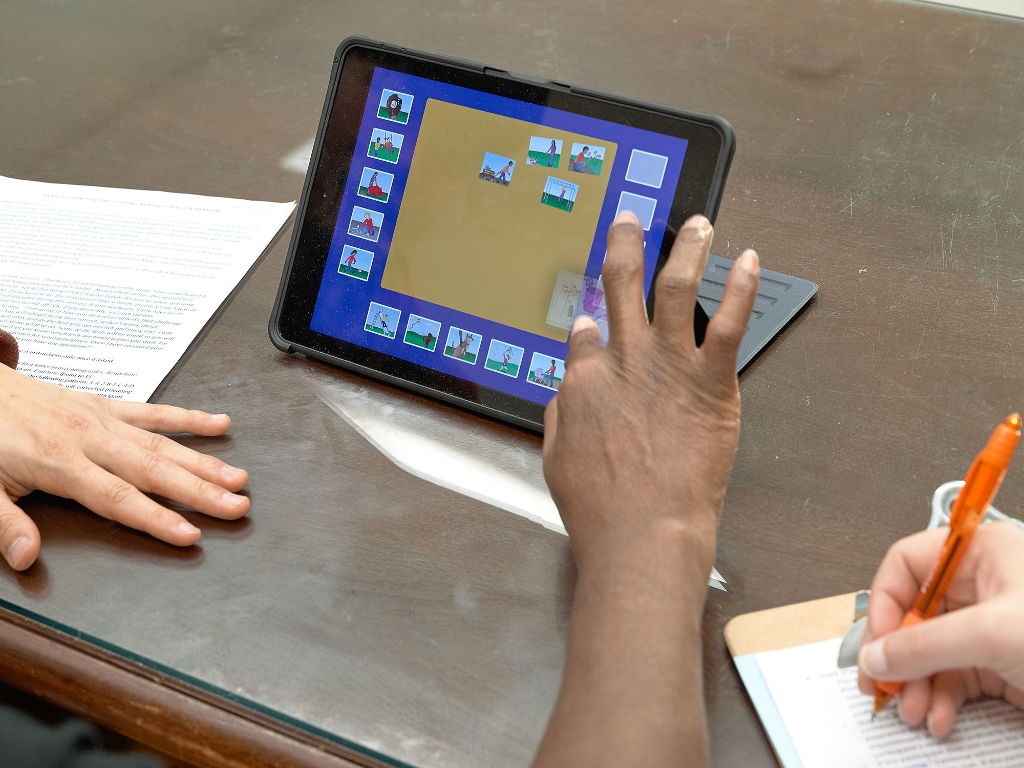 A staff member completes a cognitive test on an iPad.