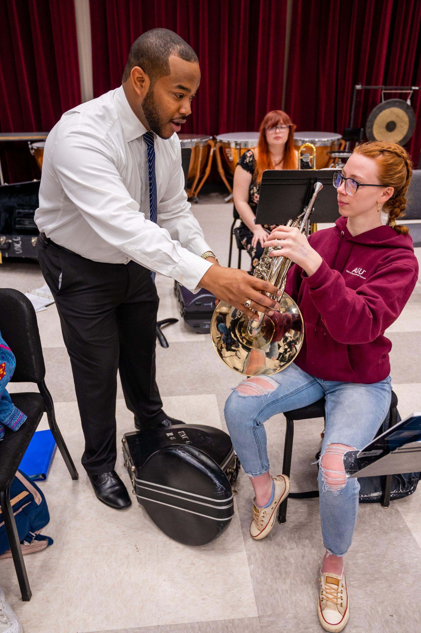 Dr. Parker instructing a student playing a brass instrument.