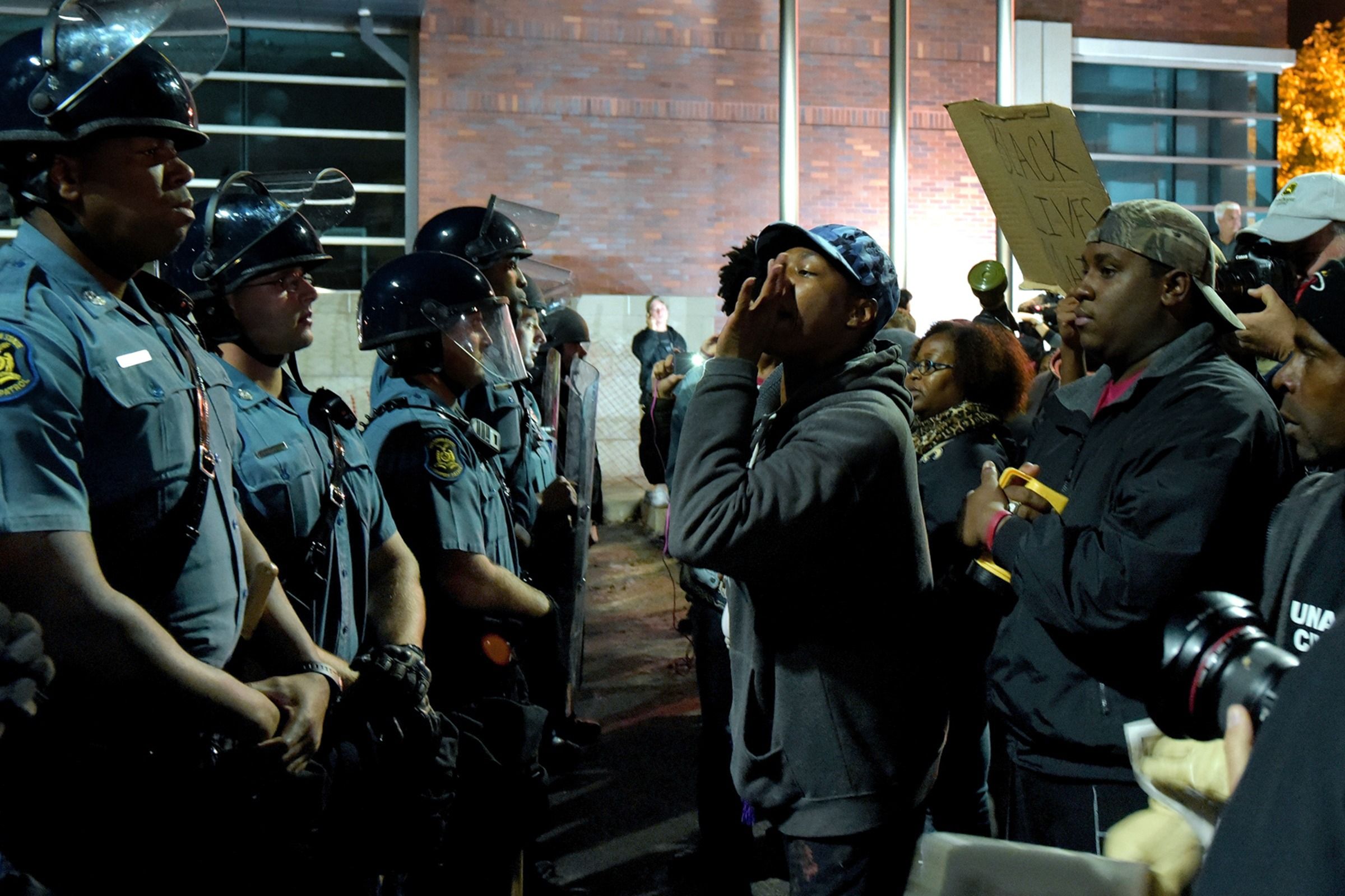 Protesters for Black Lives Matter facing a line of police officers