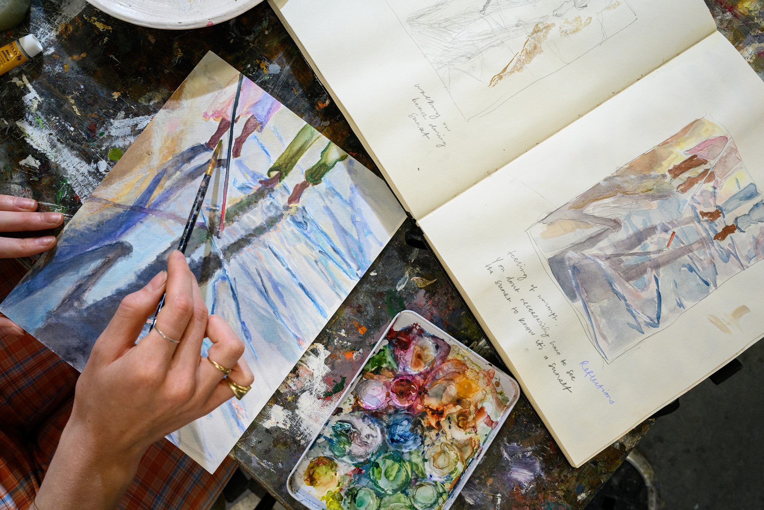 A pair of hands painting a water color