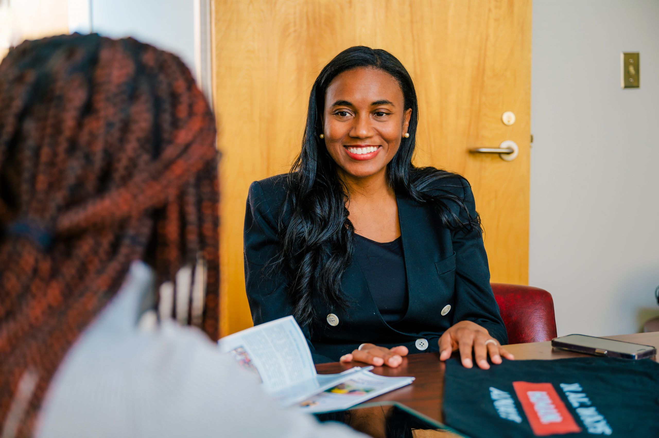 "In All Ways Human" project leader, Dr. Jocelyn Smith Lee, sitting at a table smiling.