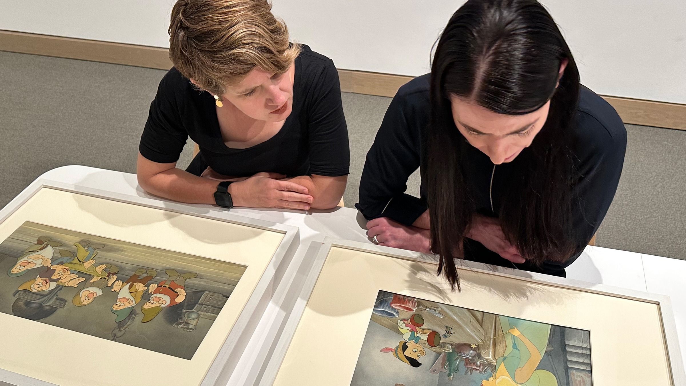 Heather Holian and Emily Stamey looks over frames from Disney's "Pinocchio" and "Snow White"