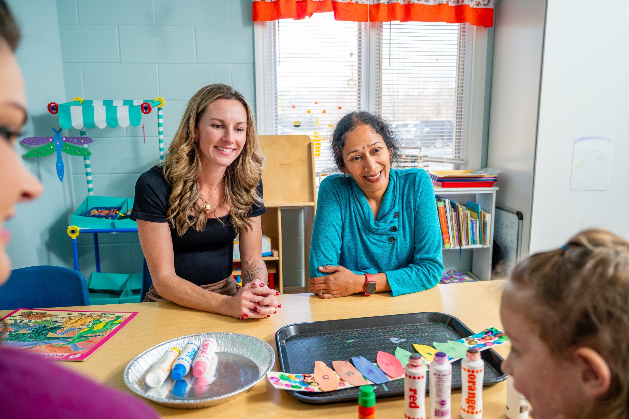 Amanda FLynt and preschool teacher interact with student