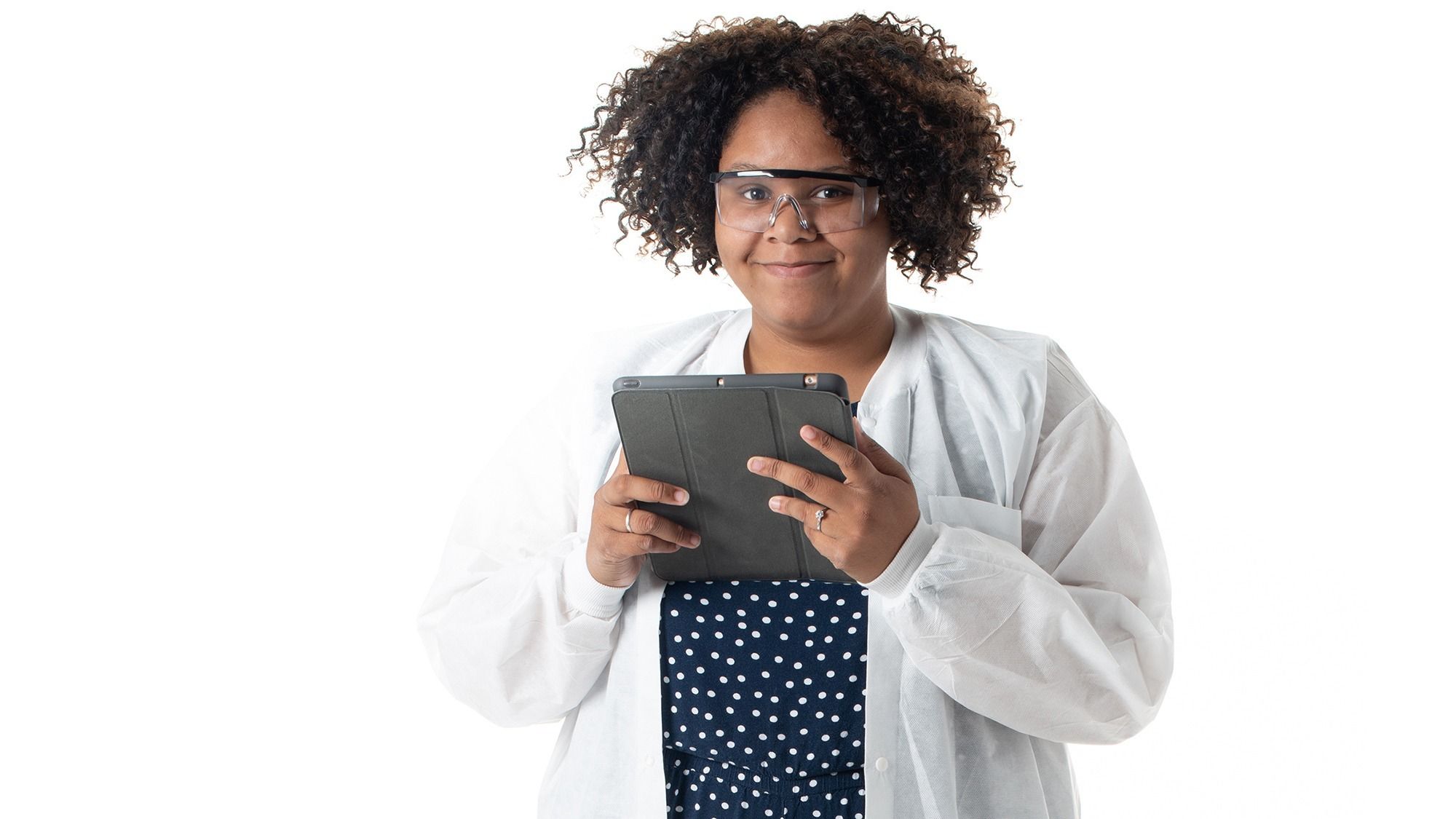 Undergraduate researcher Viola Munos wearing a lab coat and holding an iPad that she uses for her research.
