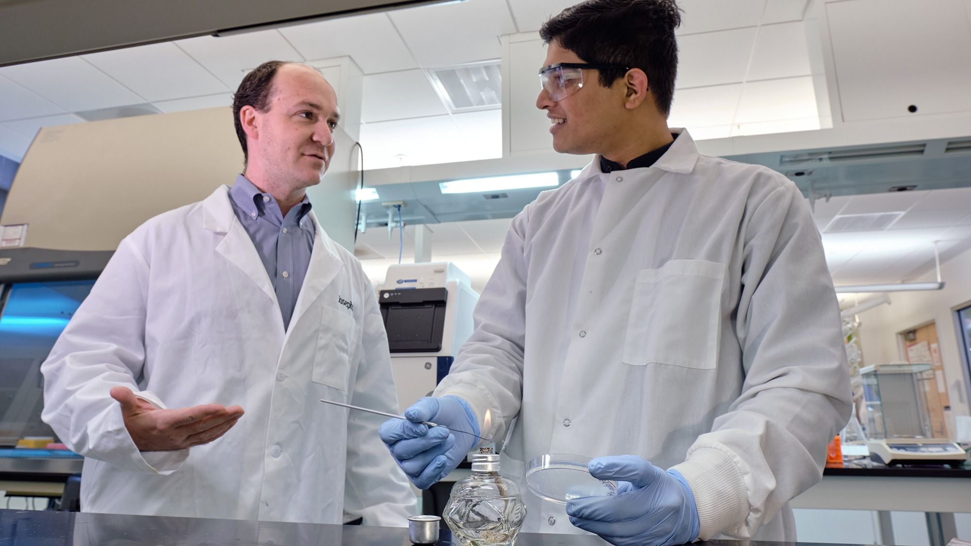 Dr. Josephs in the lab, speaking with his graduate student Parth Desai.