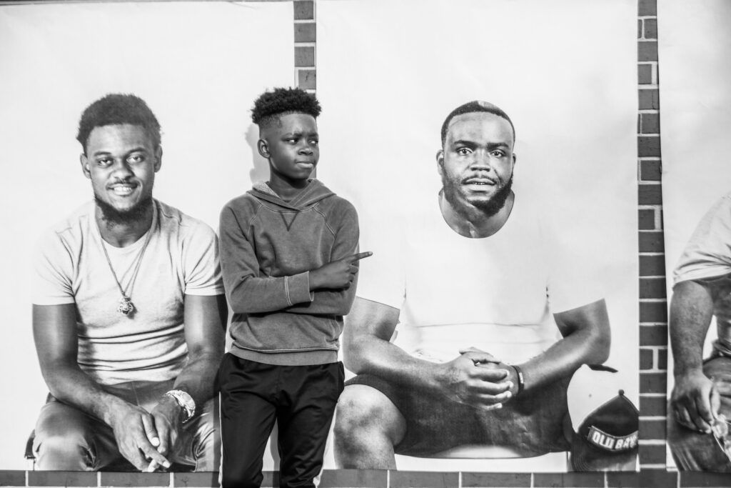 Kelvin Oliver, Jr's son standing in front of and pointing to a portrait of his father.