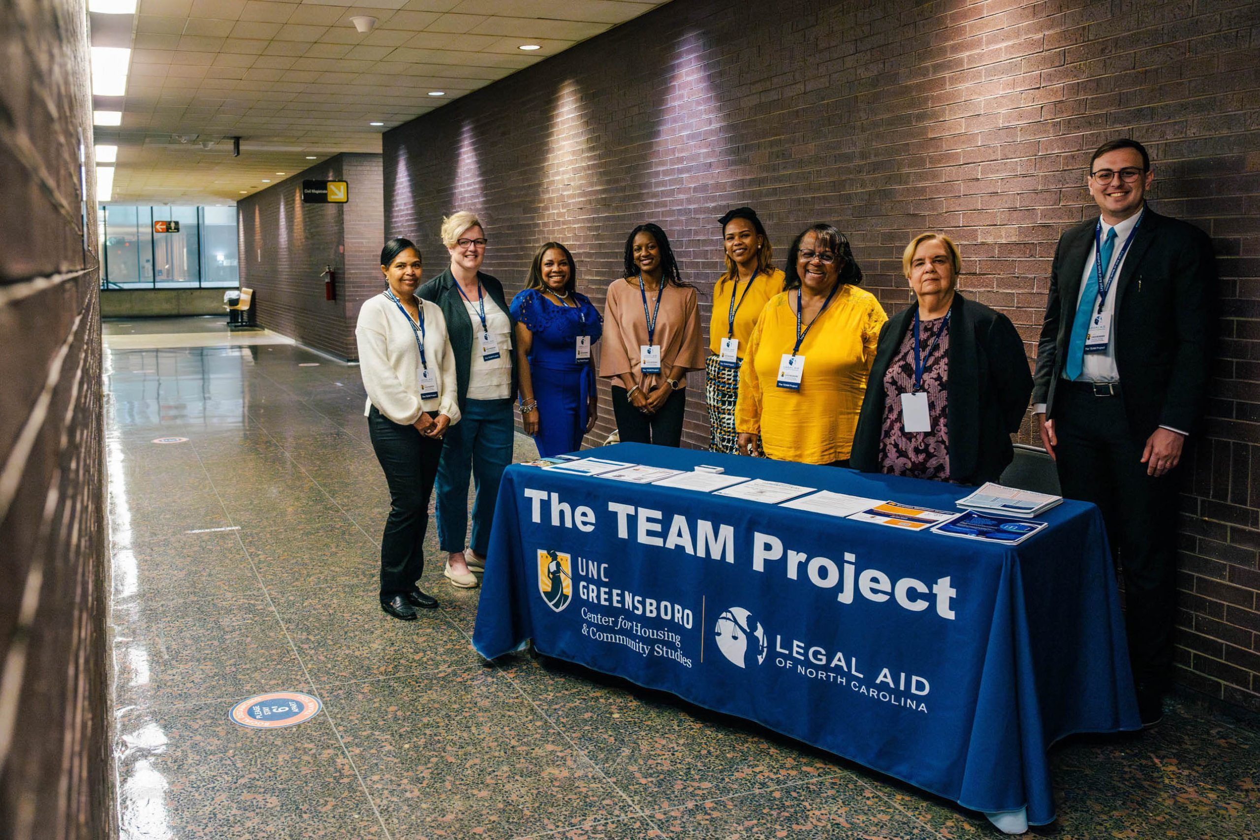 The CHCS and Legal Aid teams stand at their booth in the Guilford County Courthouse