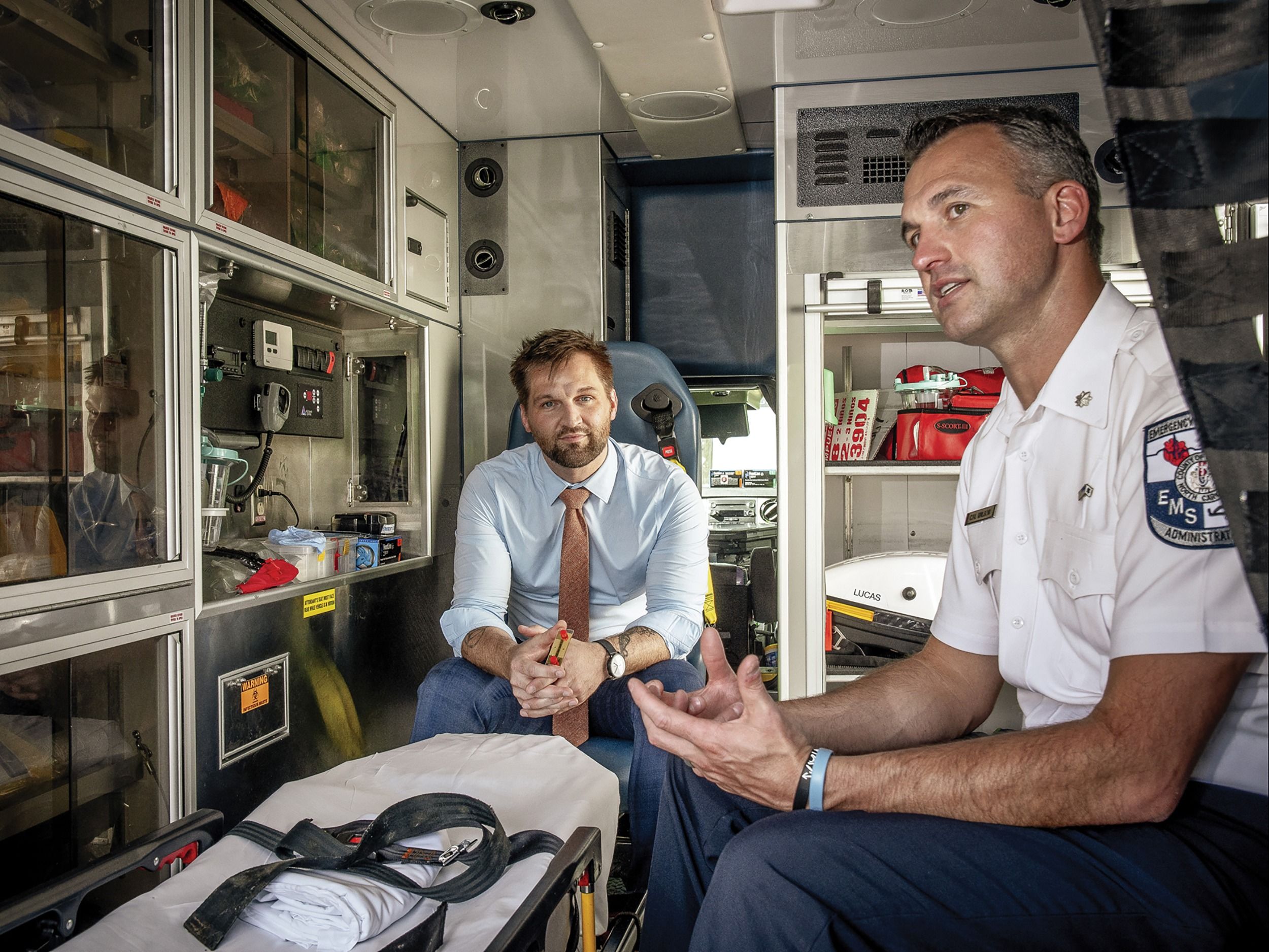 Taylor Mabe and a first responder discuss a device to detect heart attacks.