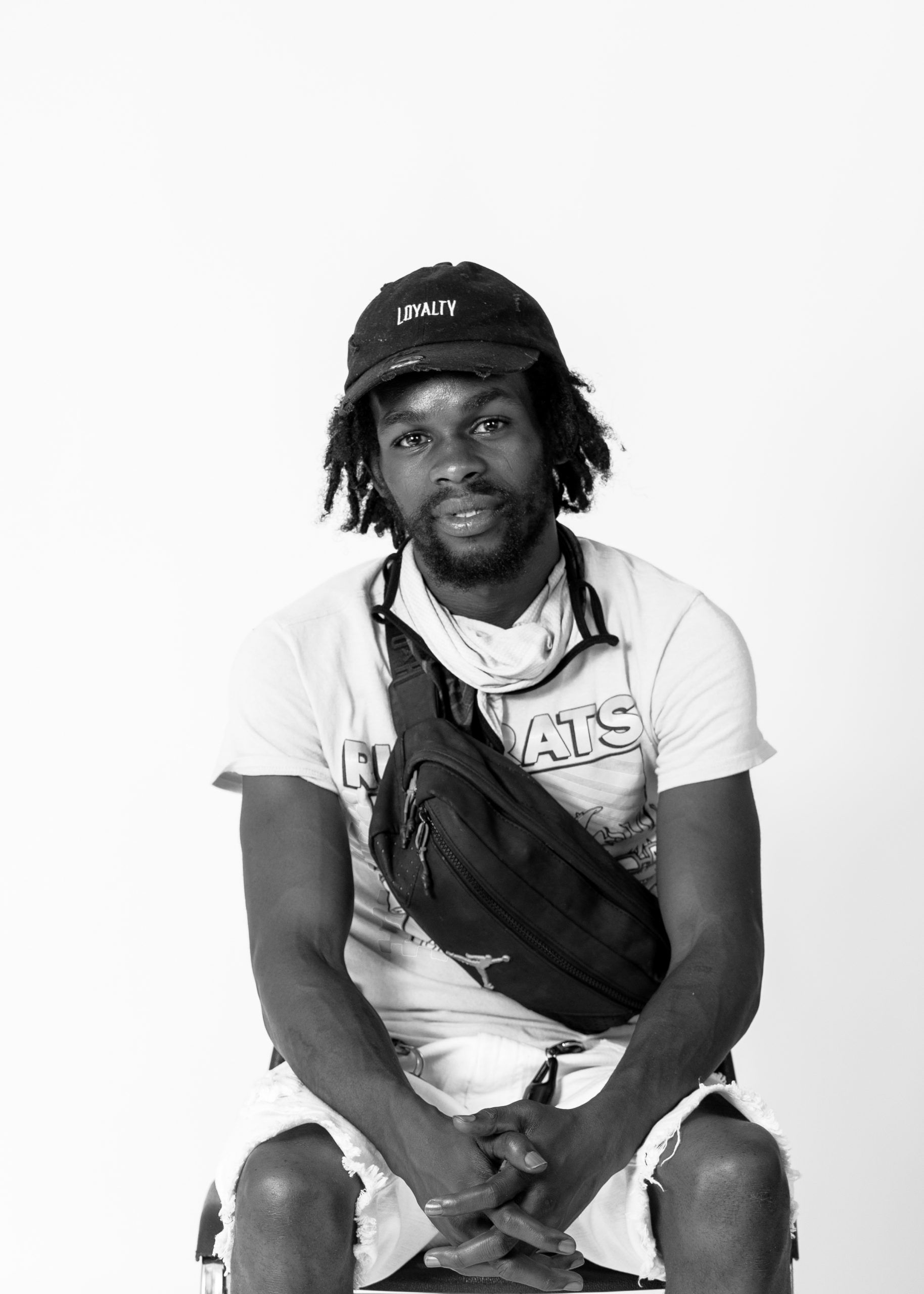 Black and white photo of a Black man with a beard and hat.