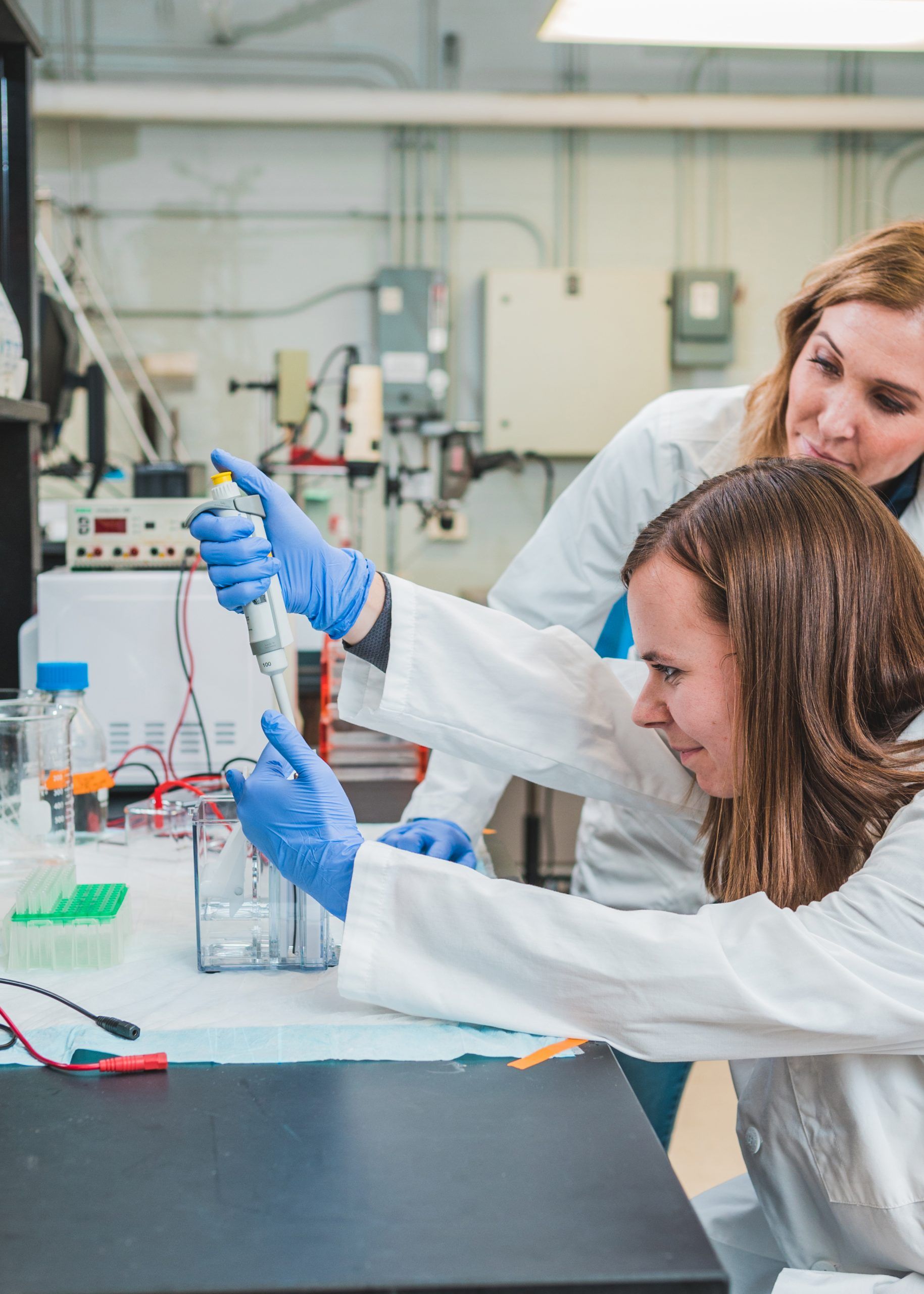 Grad Student Louisa Tichy using a syringe as Dr. Parry watches.