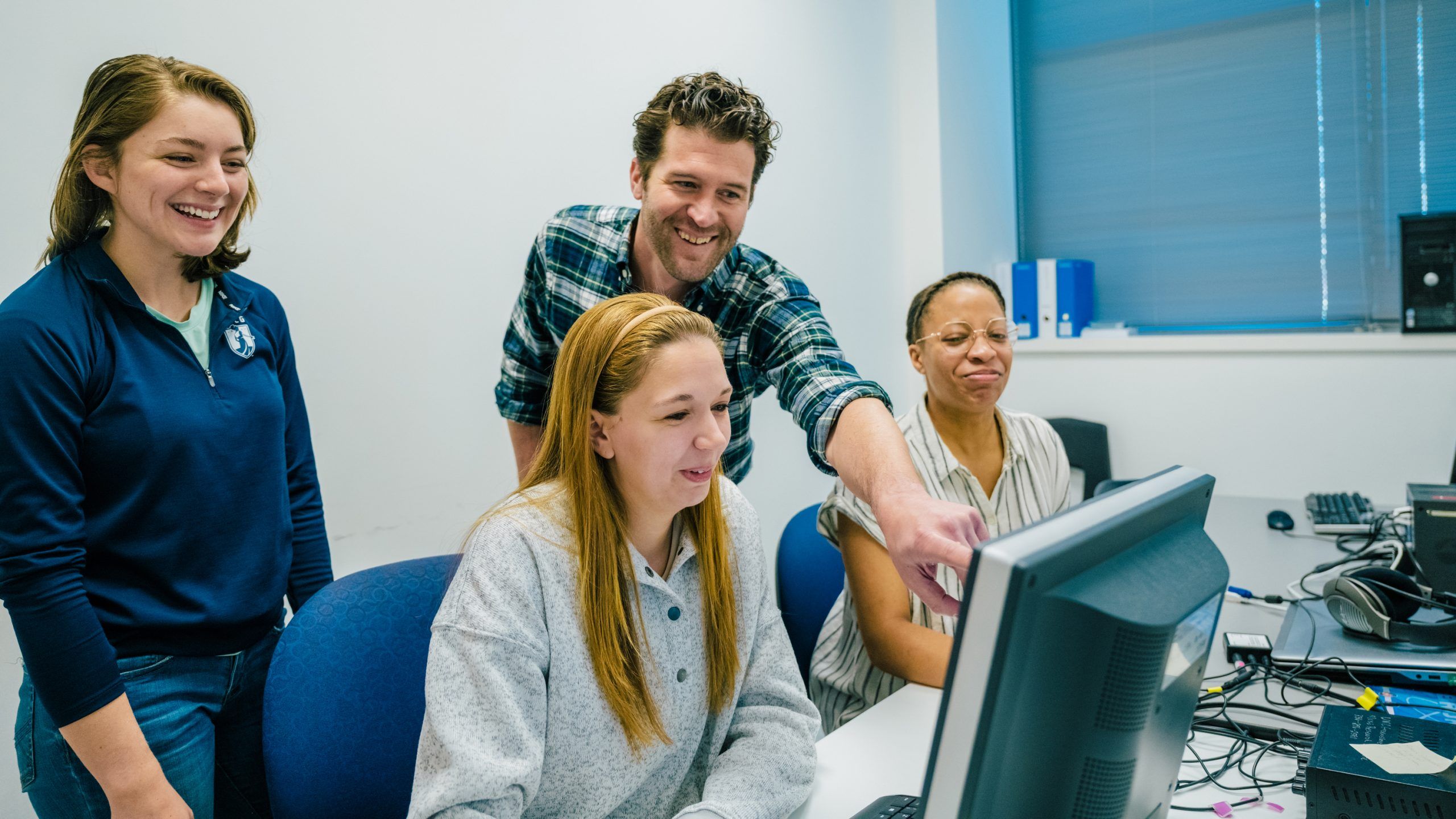 Students and a professor looking over research findings