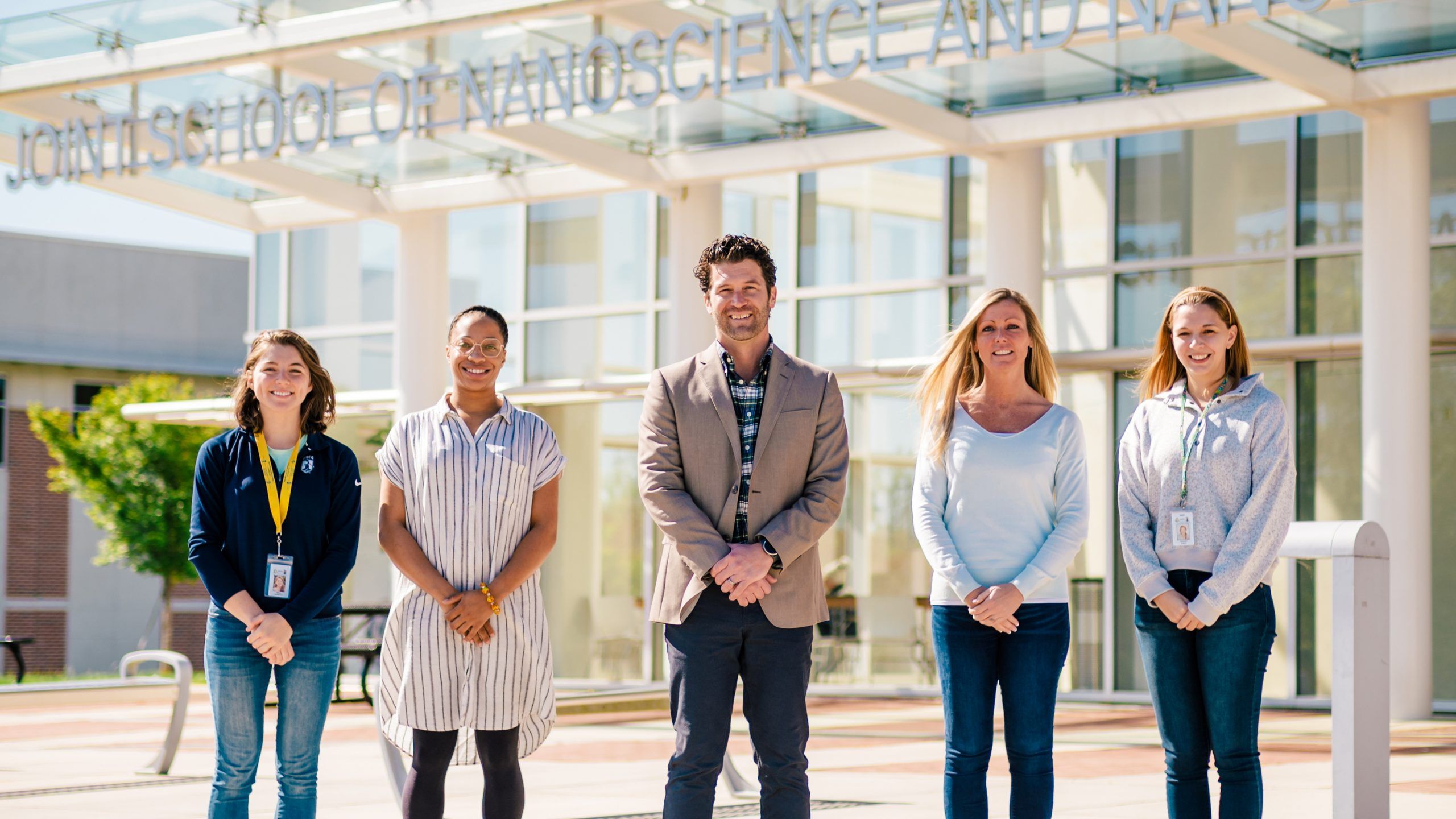 five people standing outside of UNCG JSSN building