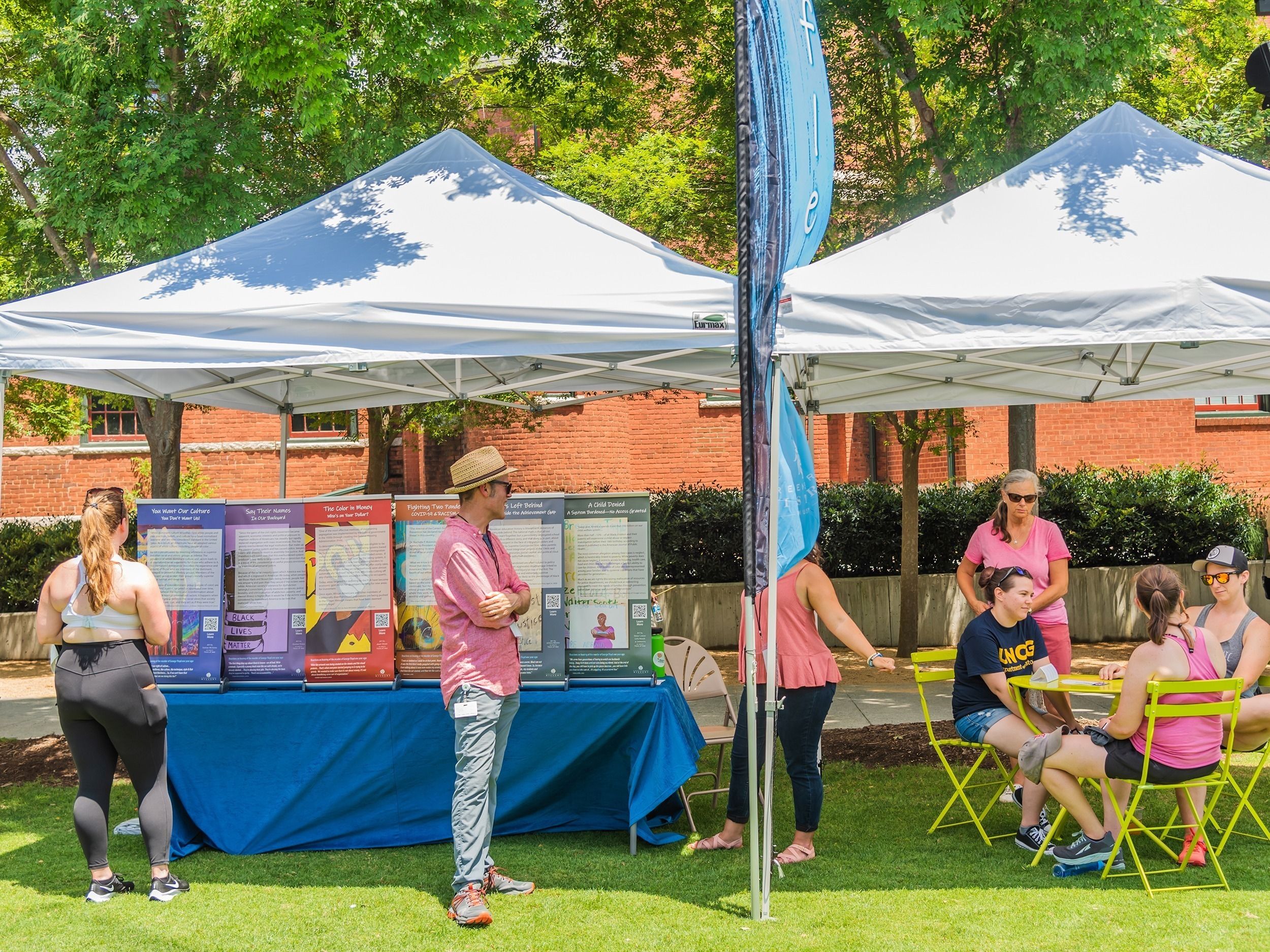 Volunteers gather around an information table at LeBauer park.