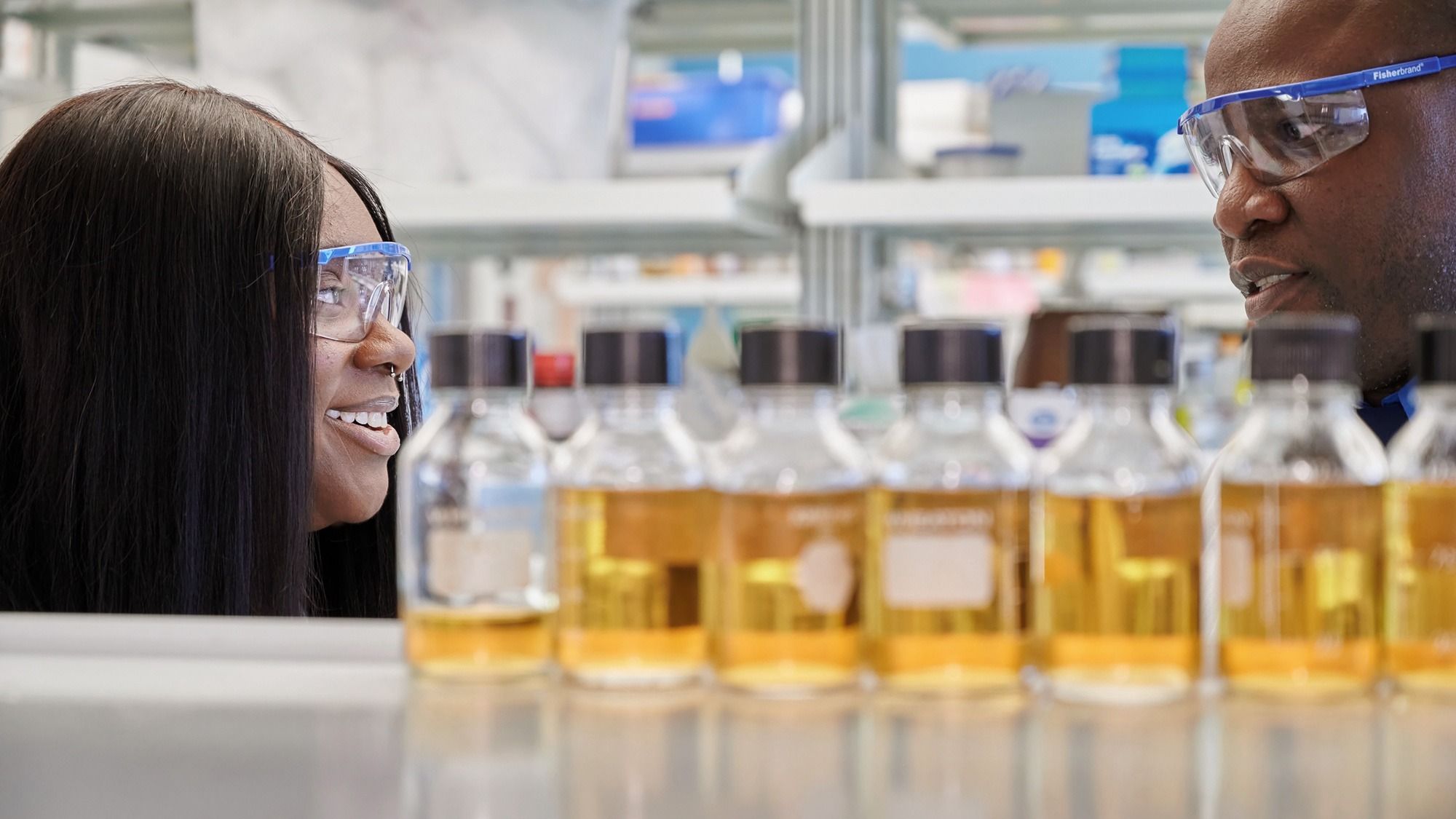 An undergraduate researcher speaking with her mentor in the lab.