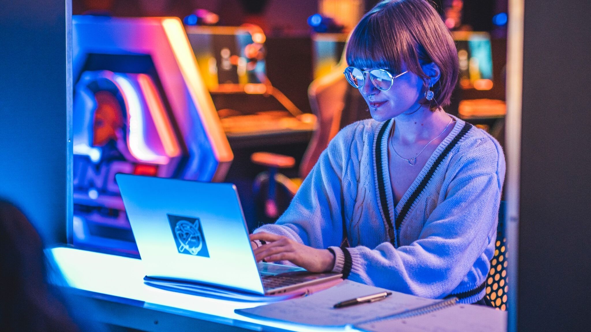 Undergraduate student Sophia Rosenberg sits in UNCG's E-Sports arena as they work on their laptop