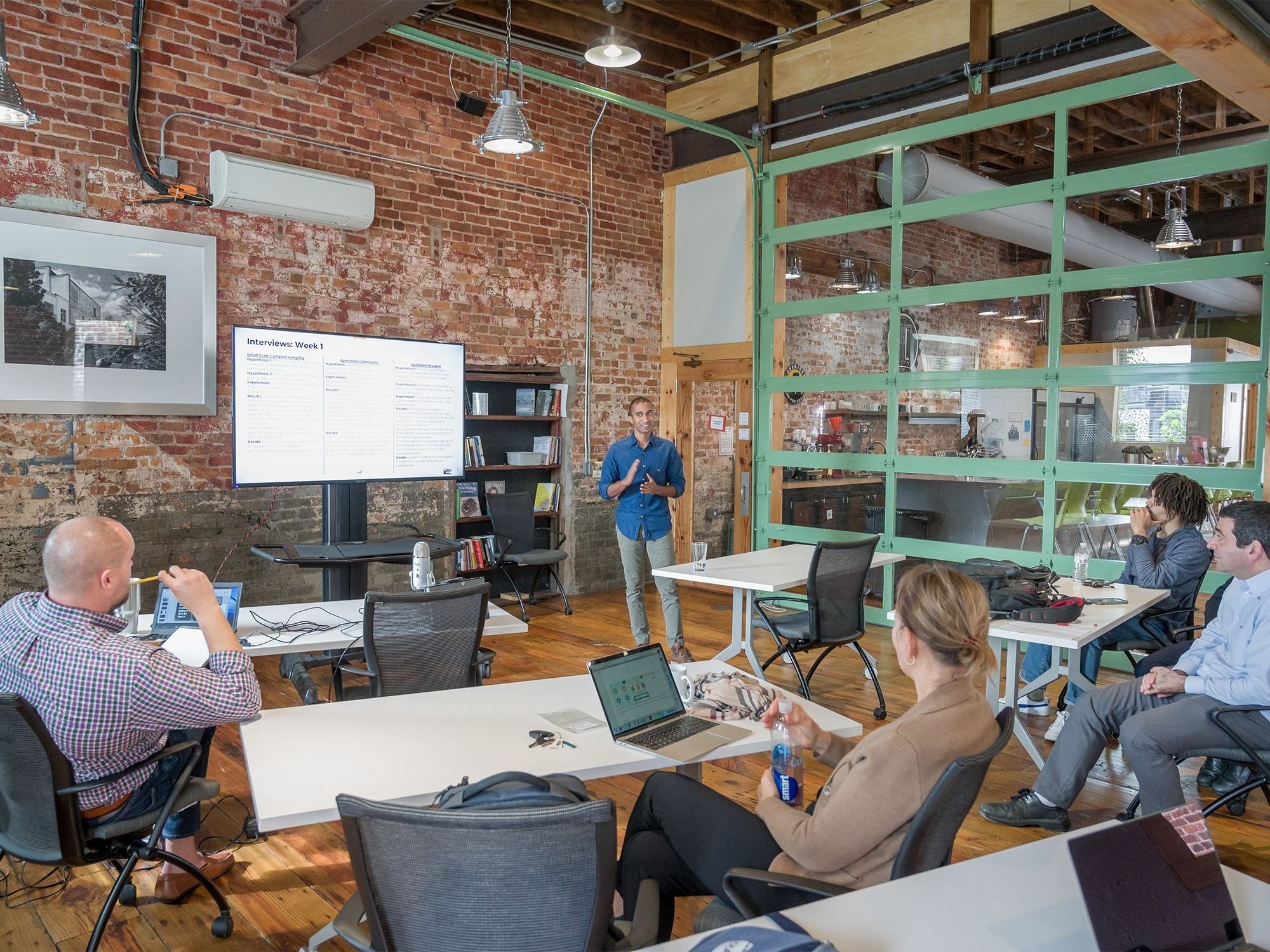 A group listens to an entrepreneur presentation during an I-Corps event at HQ Greensboro.