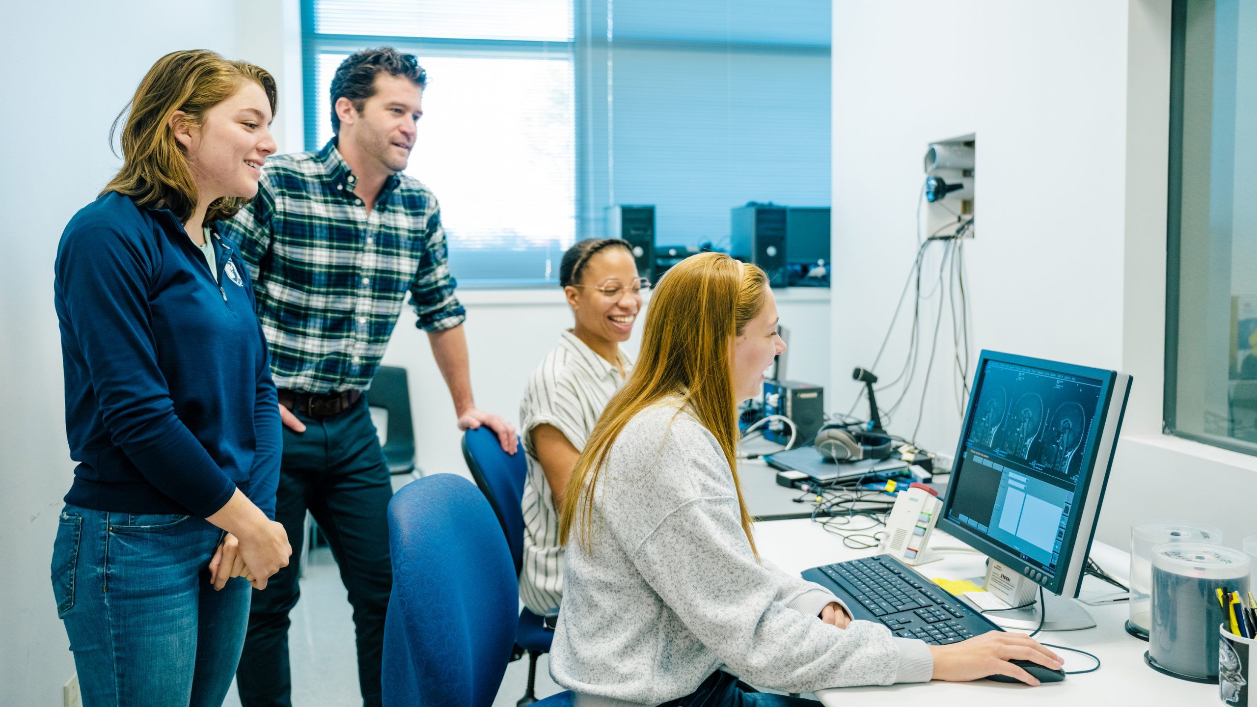 Researchers reading data over the shoulder of a student