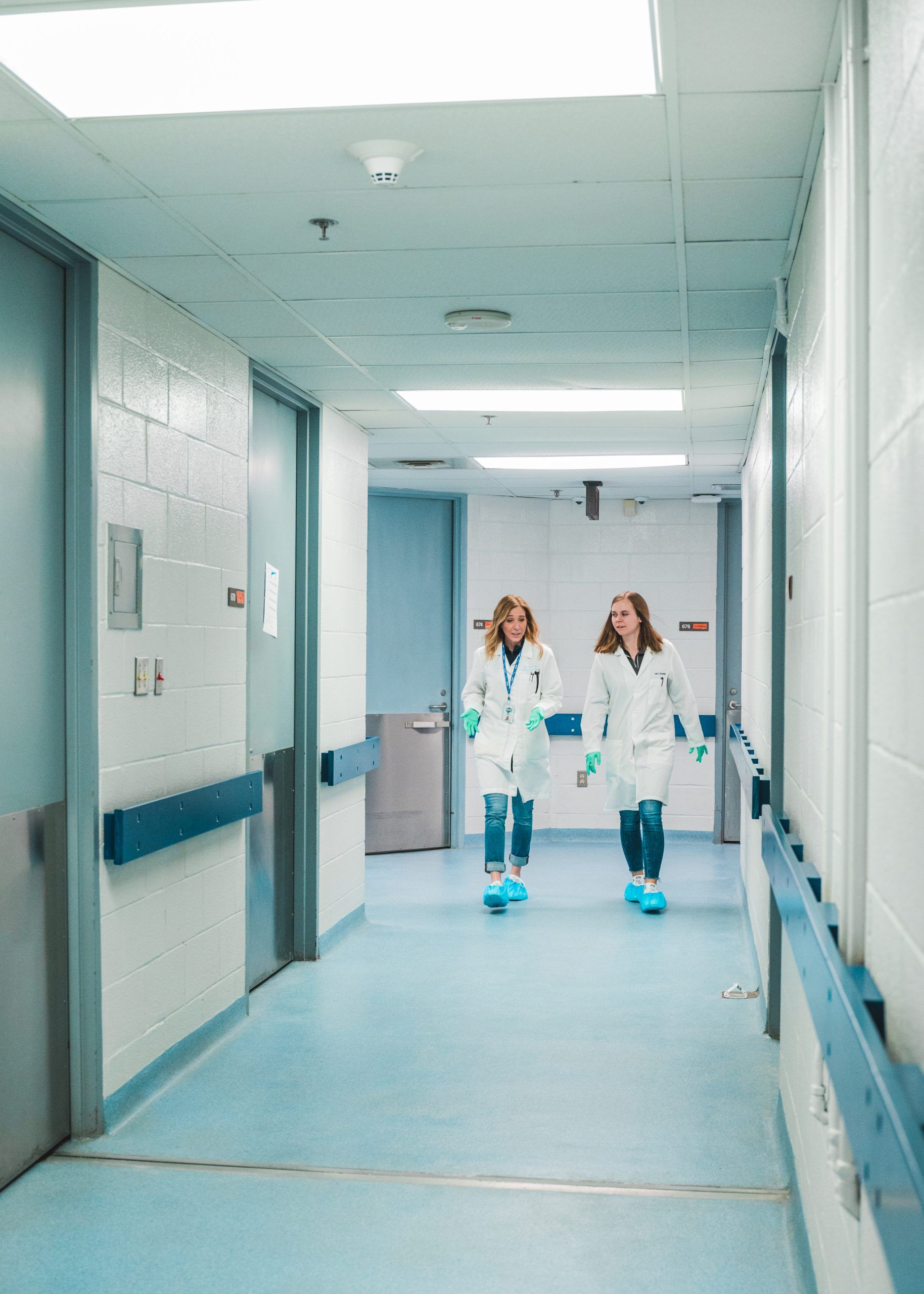 Tichy and Parry walking down a hallway.