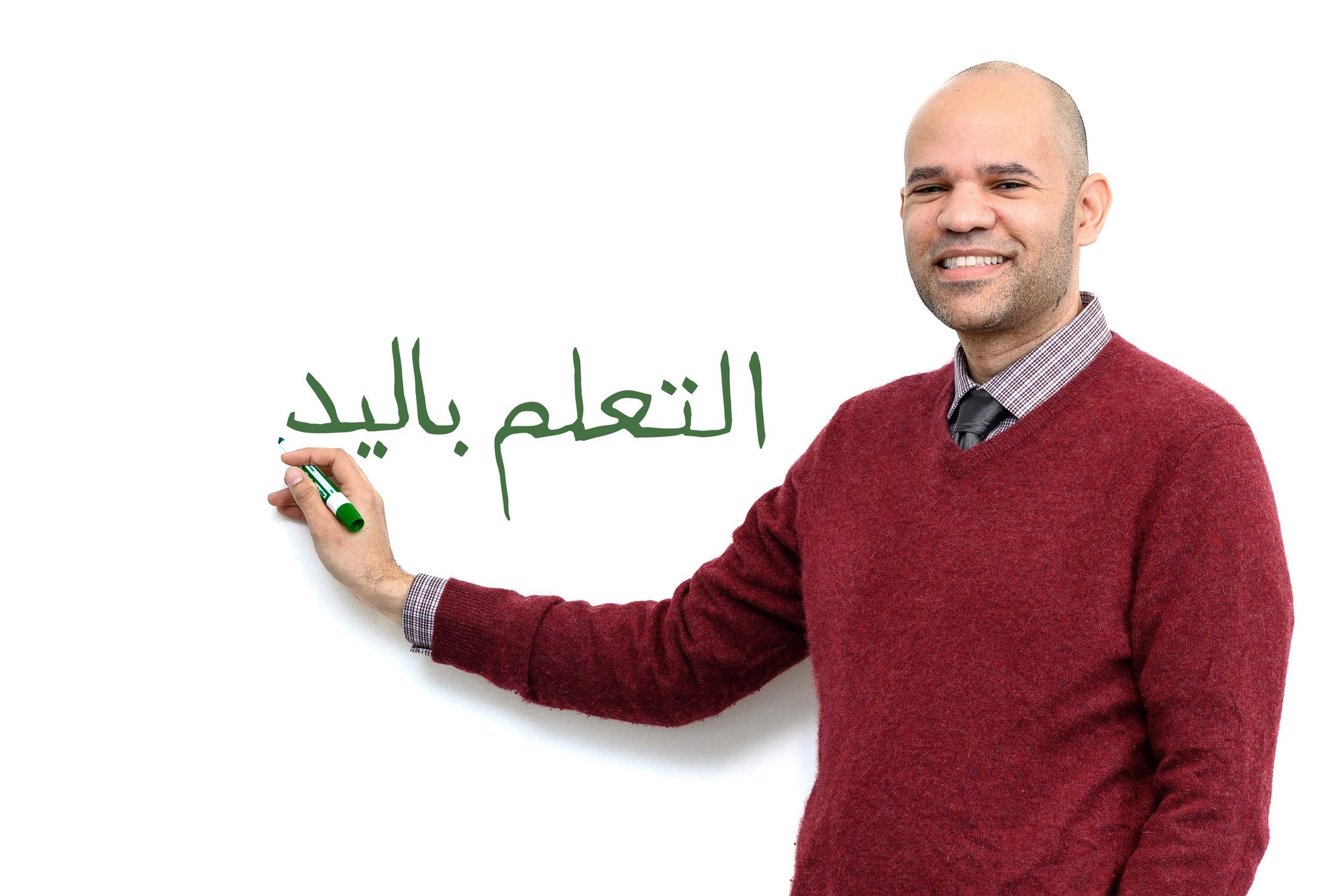 Dr. Robert Wiley demonstrates writing in Arabic on a whiteboard.