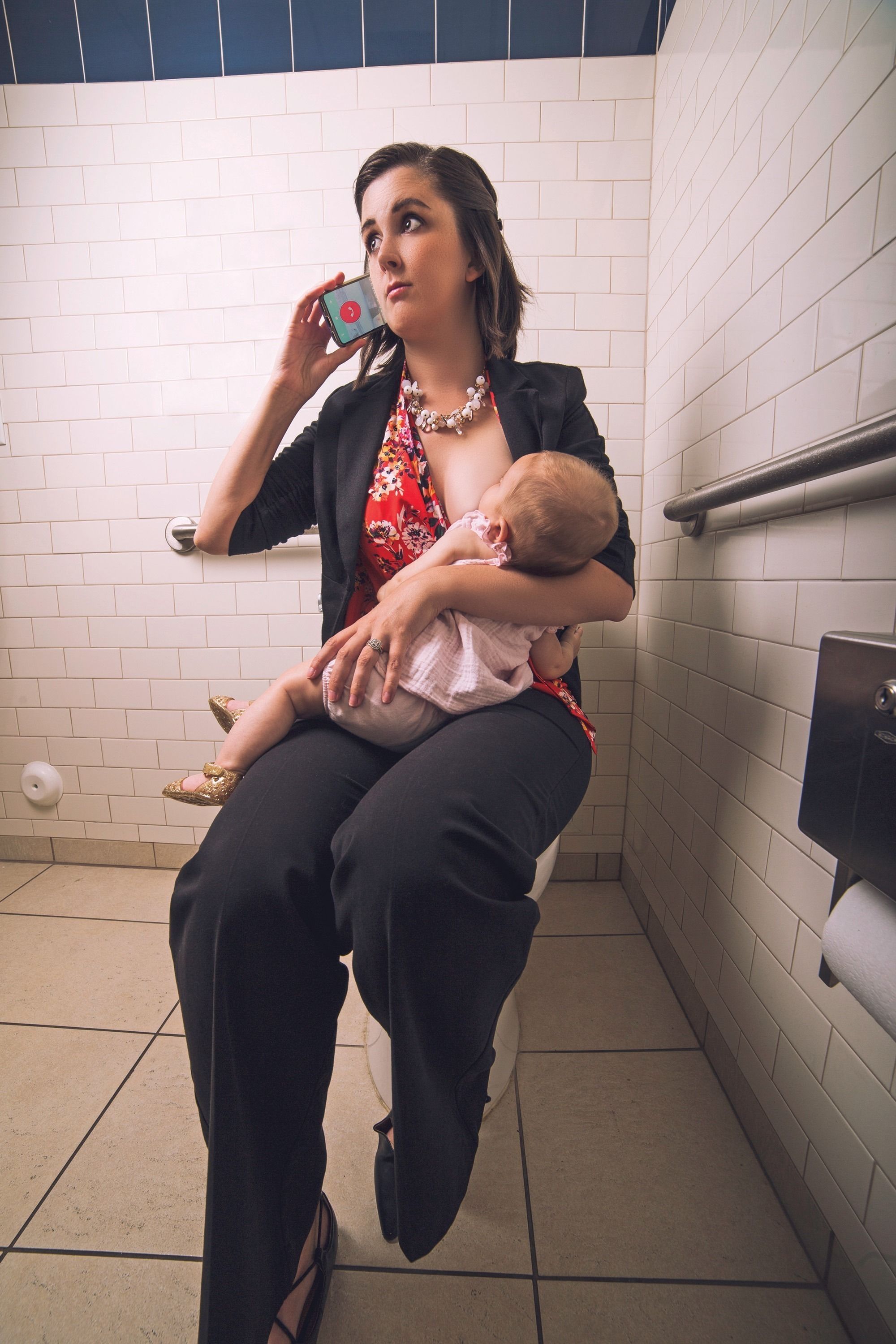 A woman breastfeeding her infant in an accessible bathroom