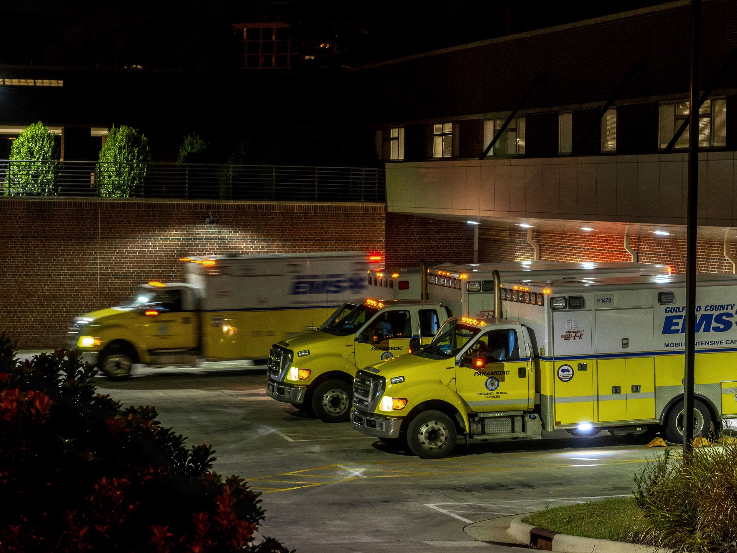 Three ambulances outside of a hospital.