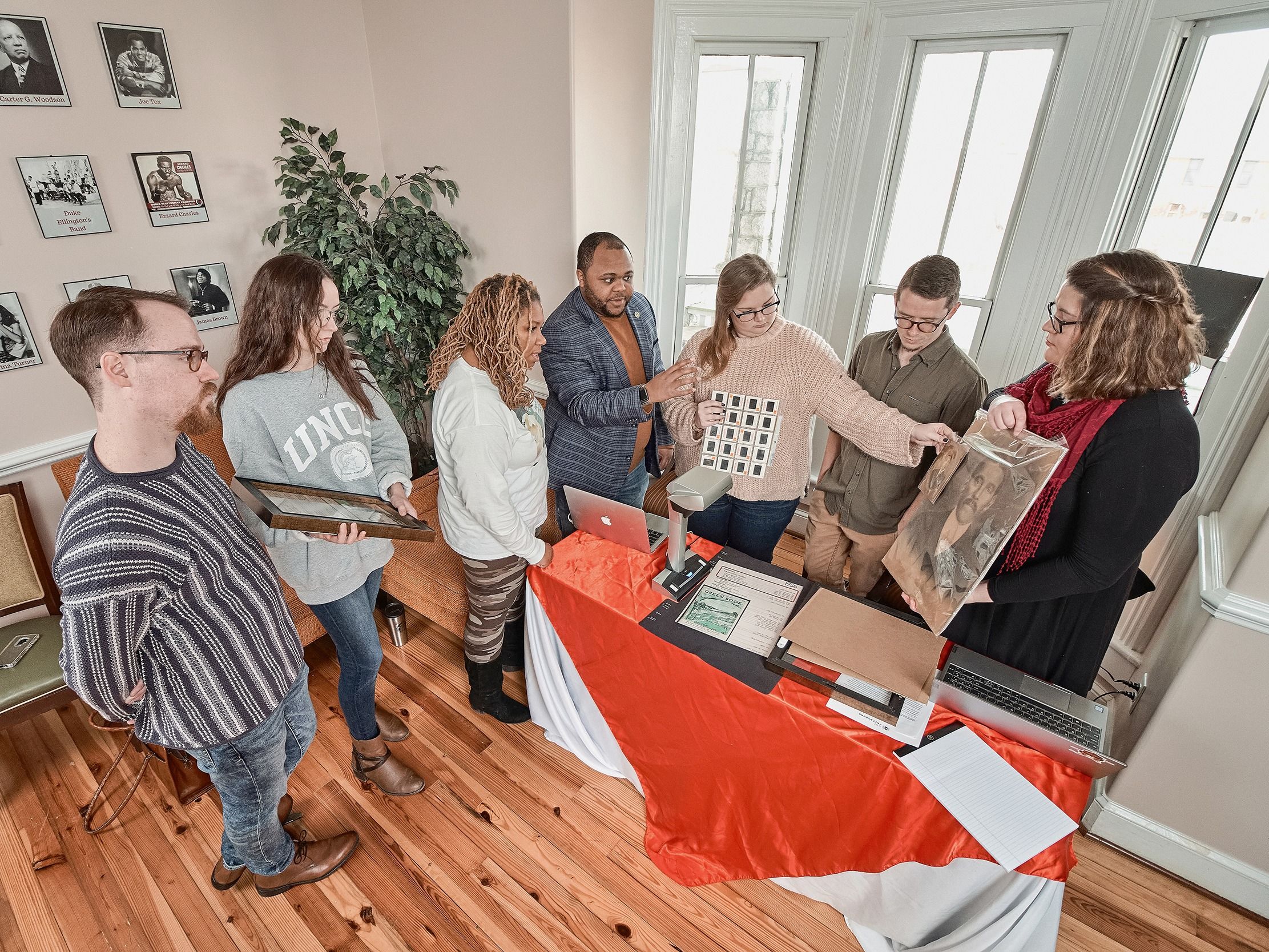 Gatson and graduate students examine archival photos