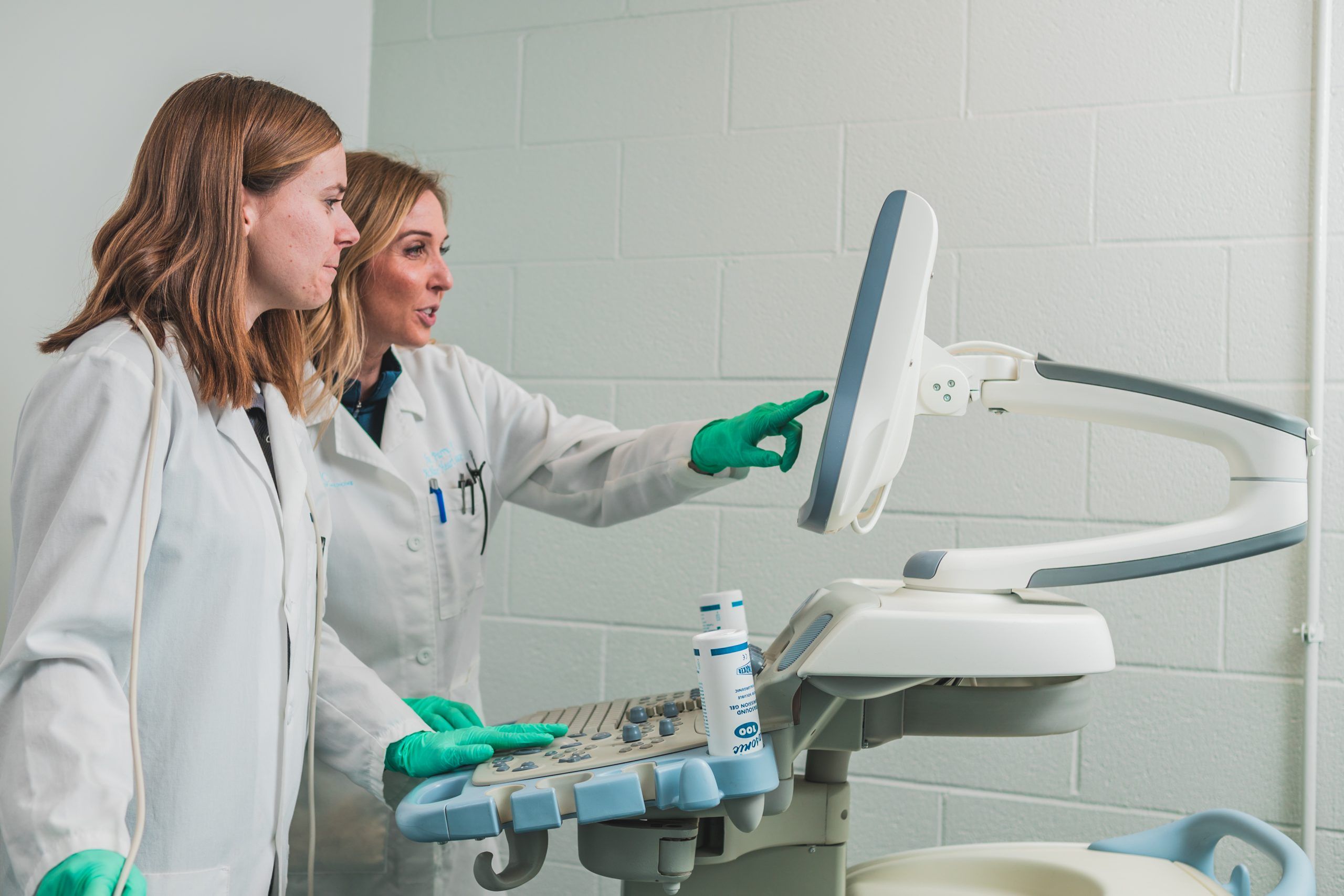 Dr. Traci Parry and her doctoral student Louisa Tichy observing a computer monitor.